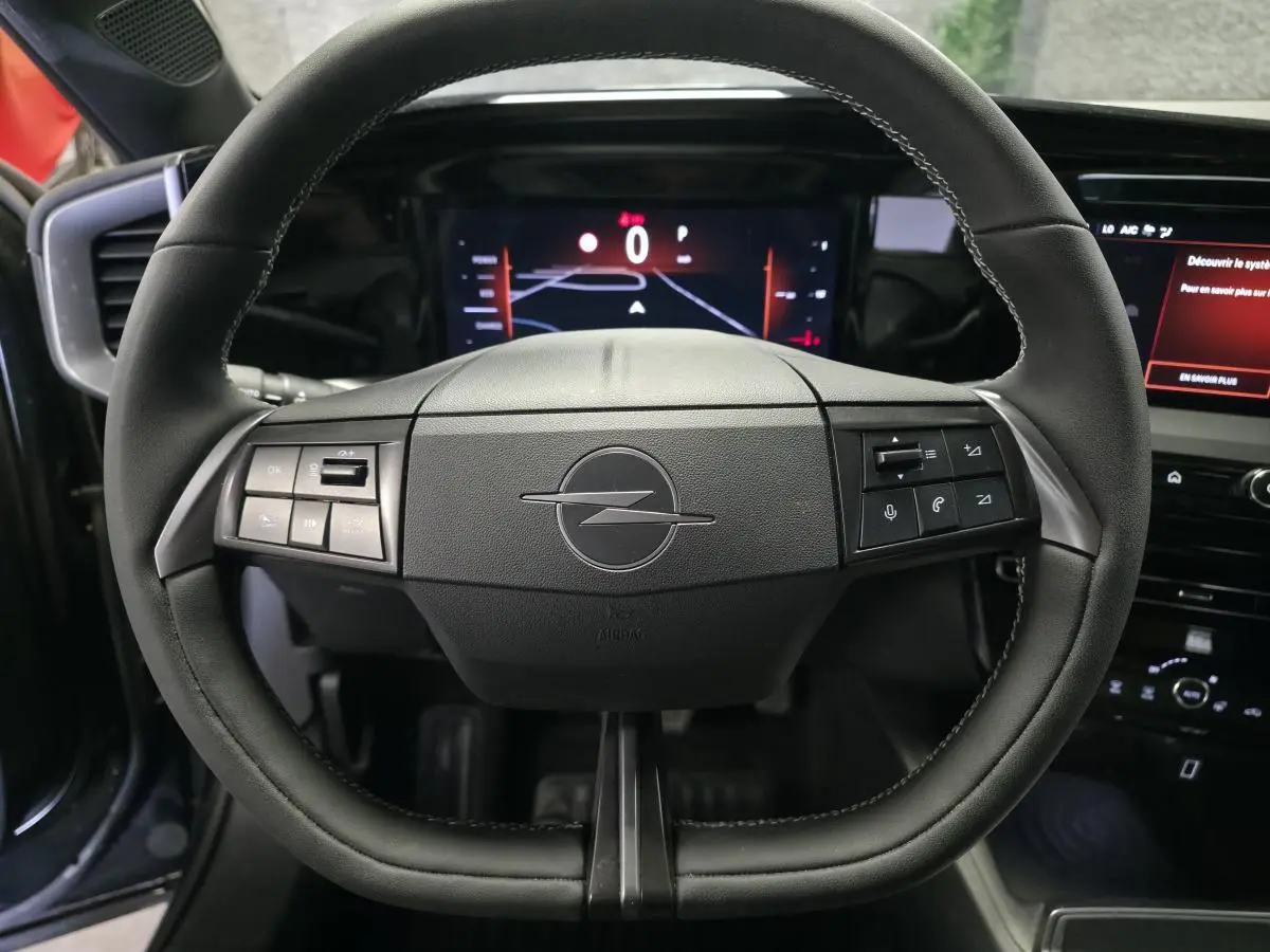 Vue rapprochée du volant noir de l’Opel Mokka 2025 avec commandes intégrées et tableau de bord digital.