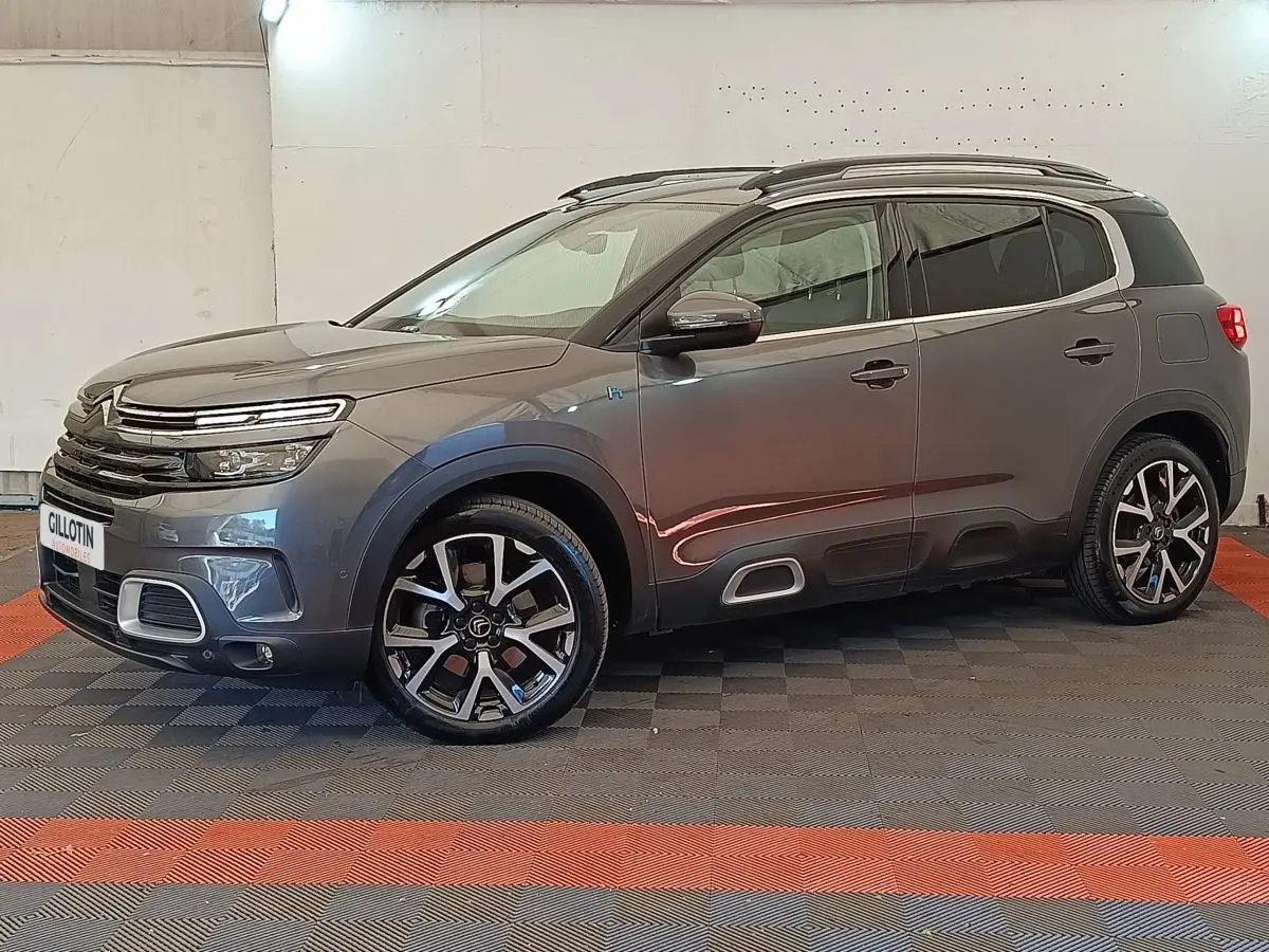Citroën C5 Aircross Hybrid gris foncé en vue profil côté gauche, avec jantes alliage et barres de toit chromées.