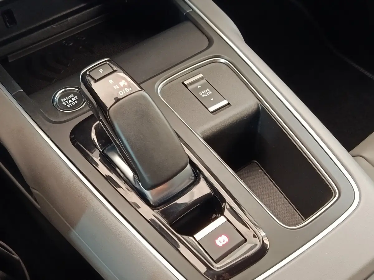 Gros plan sur la console centrale intérieure du Citroën C5 Aircross Hybrid 225 ë-EAT8 avec levier de vitesse et bouton Start/Stop.