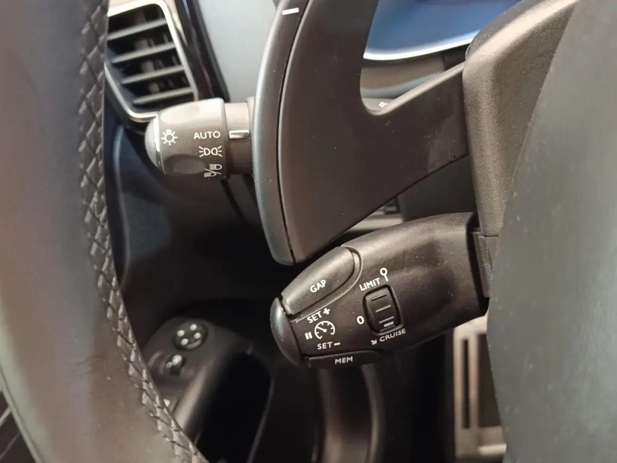 Gros plan sur les commandes au volant d’un Citroën C5 Aircross Hybrid 225 ë-EAT8, intérieur noir.