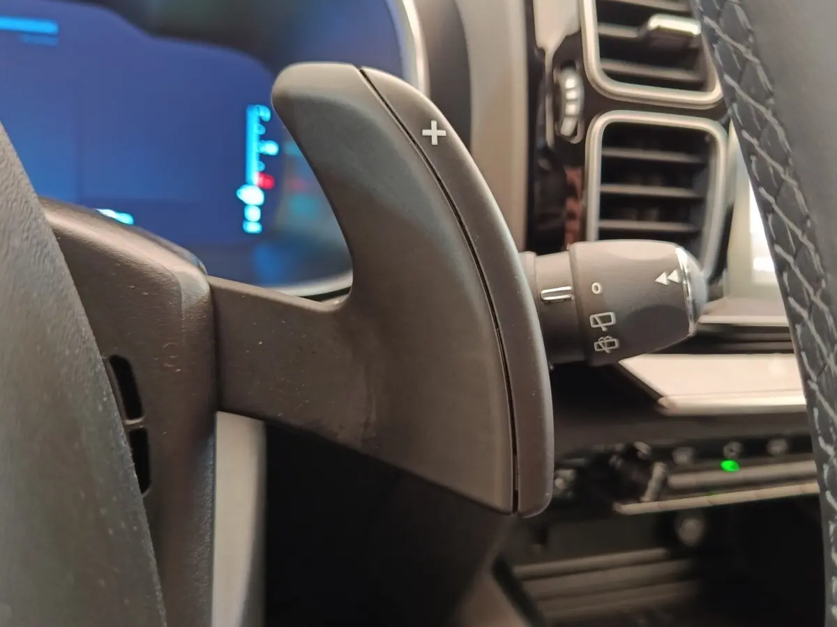 Gros plan sur la palette de changement de vitesse droite du volant cuir du Citroën C5 Aircross Hybrid gris foncé, intérieur moderne.