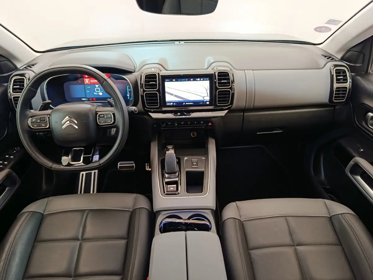 Vue intérieure avant du Citroën C5 Aircross Hybrid 225 avec tableau de bord gris et écran tactile central.