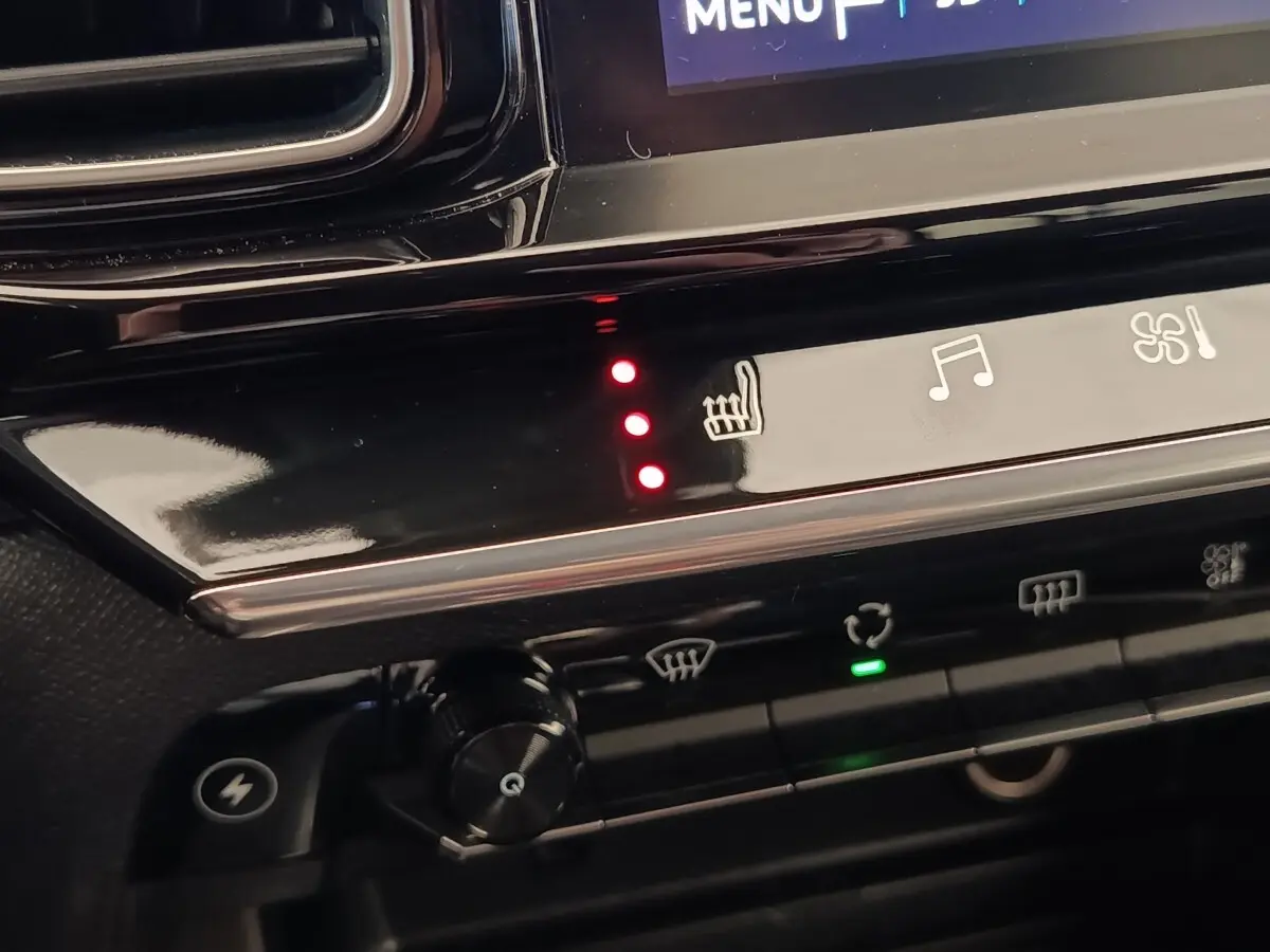 Détail du tableau de bord noir du Citroën C5 Aircross Hybrid 225, avec commandes tactiles et voyants rouges allumés.