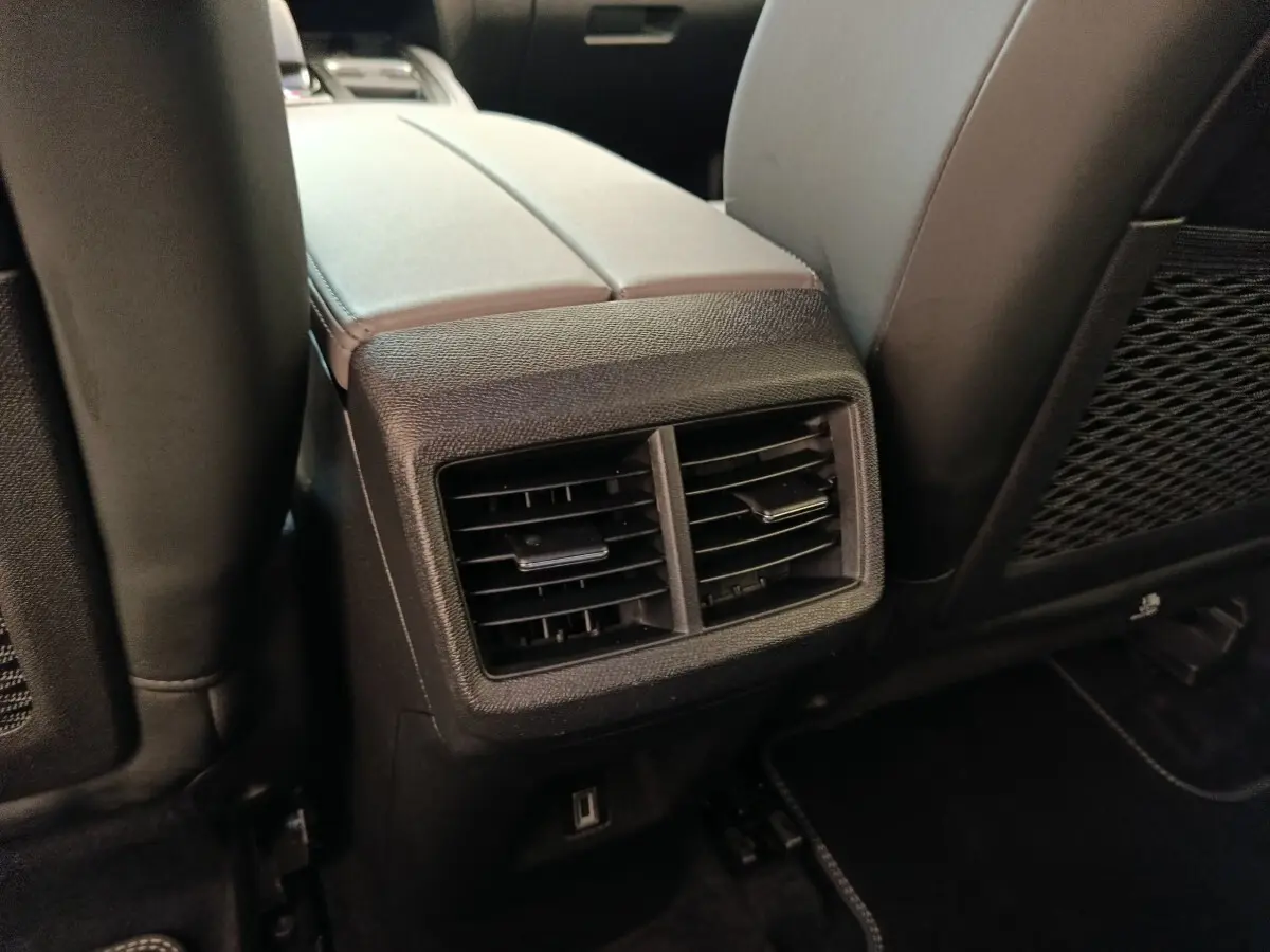 Gros plan sur la console centrale arrière avec bouches d’aération et port USB du Citroën C5 Aircross Hybrid gris foncé.