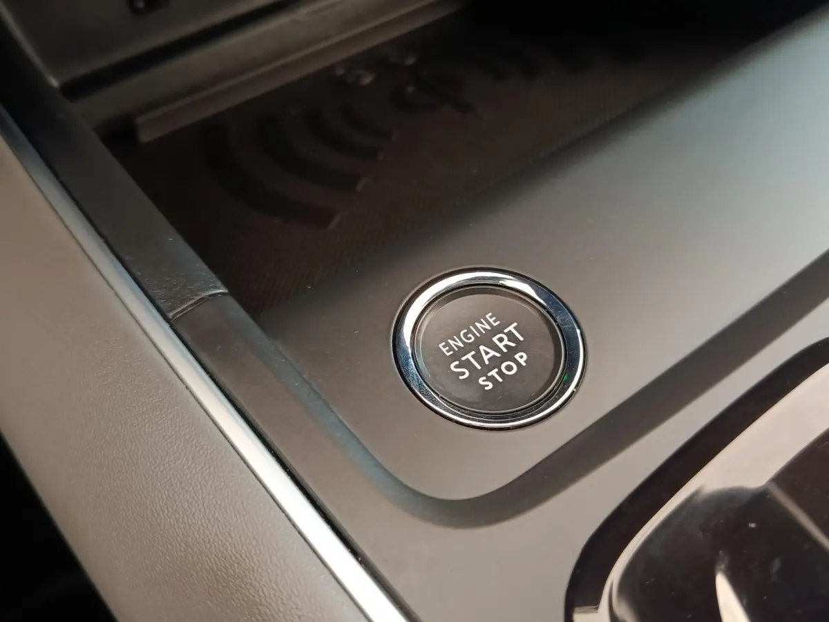 Bouton démarrage/arrêt moteur en gros plan sur la console centrale d’un Citroën C5 Aircross Hybrid gris foncé.