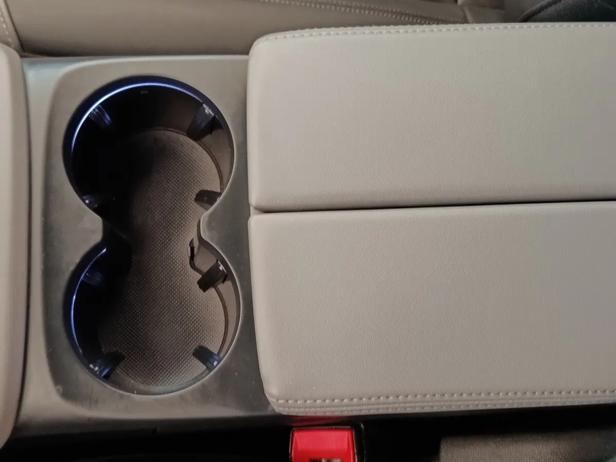 Gros plan sur la console centrale beige avec porte-gobelets et accoudoir du Citroën C5 Aircross Hybrid 225 ë-EAT8 Shine Pack.