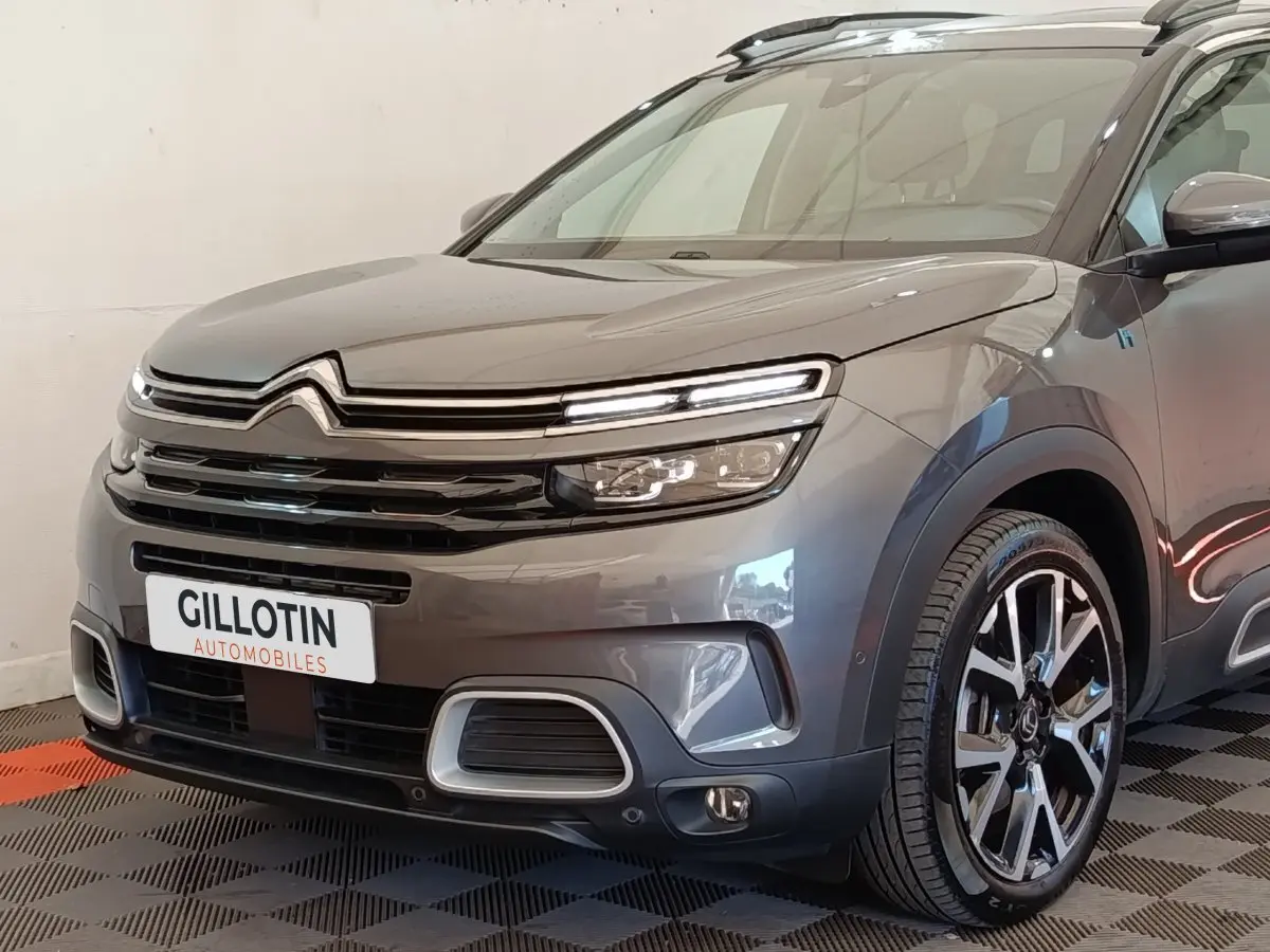 Vue 3/4 avant droite d'un Citroën C5 Aircross Hybrid gris foncé avec phares LED et jantes alliage distinctives.