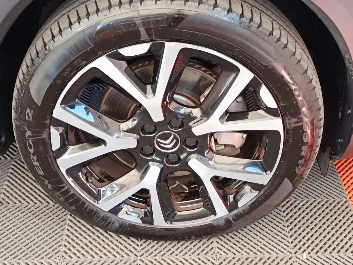 Gros plan sur la jante alliage bicolore et le pneu Pirelli d’un Citroën C5 Aircross Hybrid gris foncé.