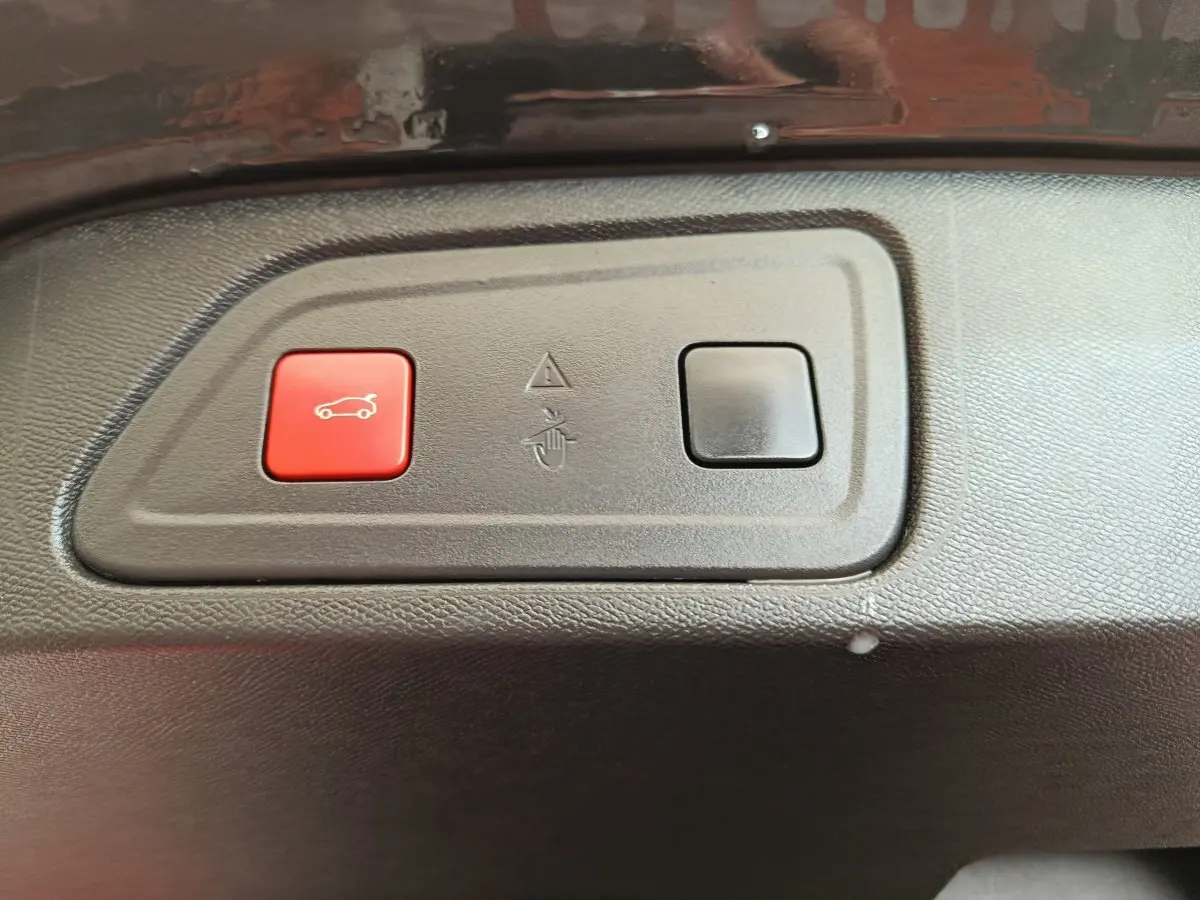 Gros plan sur les boutons d'ouverture du coffre, intérieur noir du Citroën C5 Aircross Hybrid 225 ë-EAT8 Shine Pack.