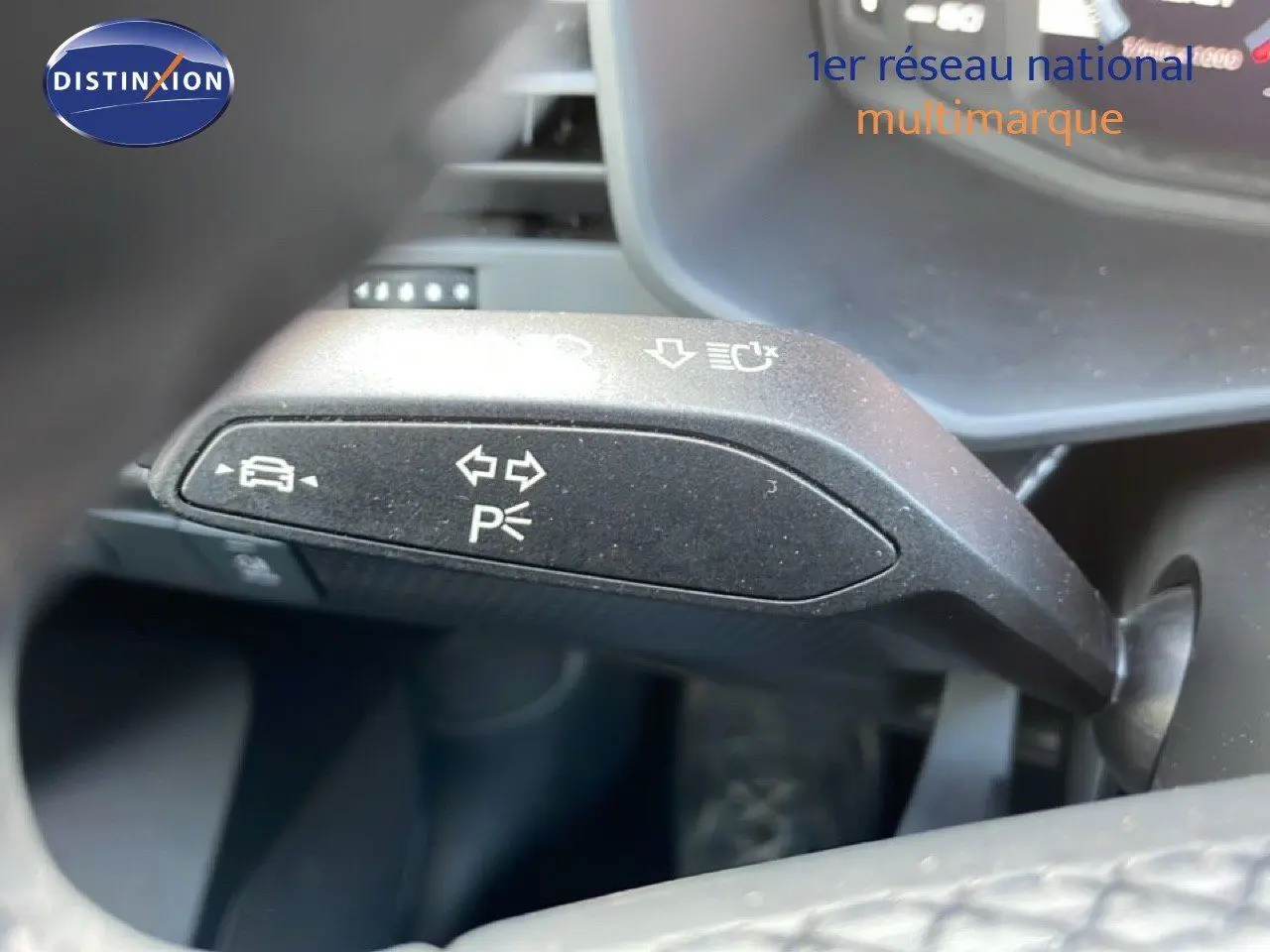 Gros plan sur la manette de clignotant et feux d'Audi A1 Sportback 2023, intérieur noir.