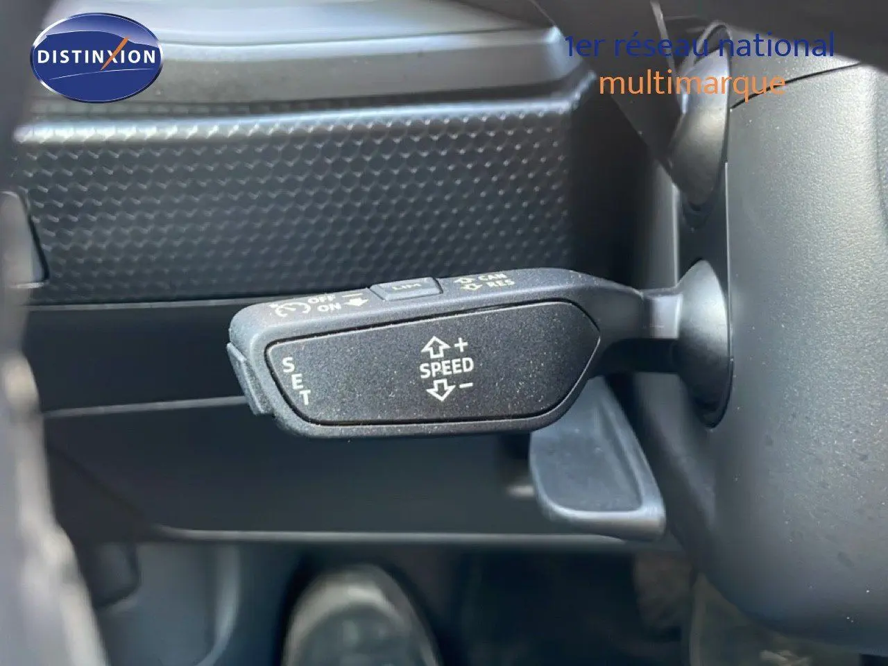 Le levier de régulateur de vitesse sur le volant d'une Audi A1 Sportback blanche glacier métal 2023.