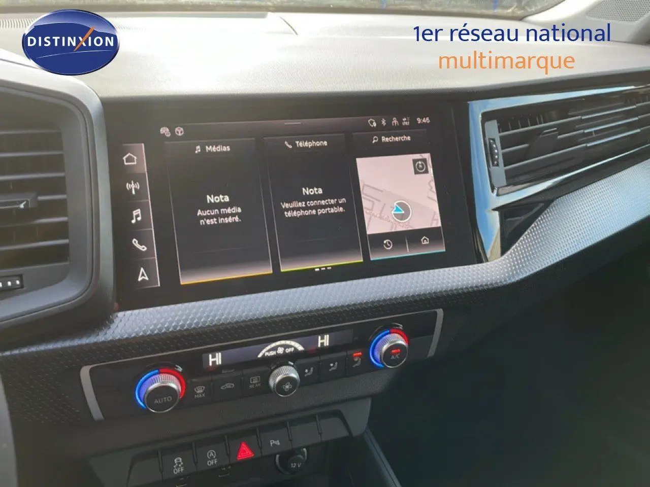 Tableau de bord de l'Audi A1 Sportback 2023 avec écran tactile et commandes de climatisation en gros plan.