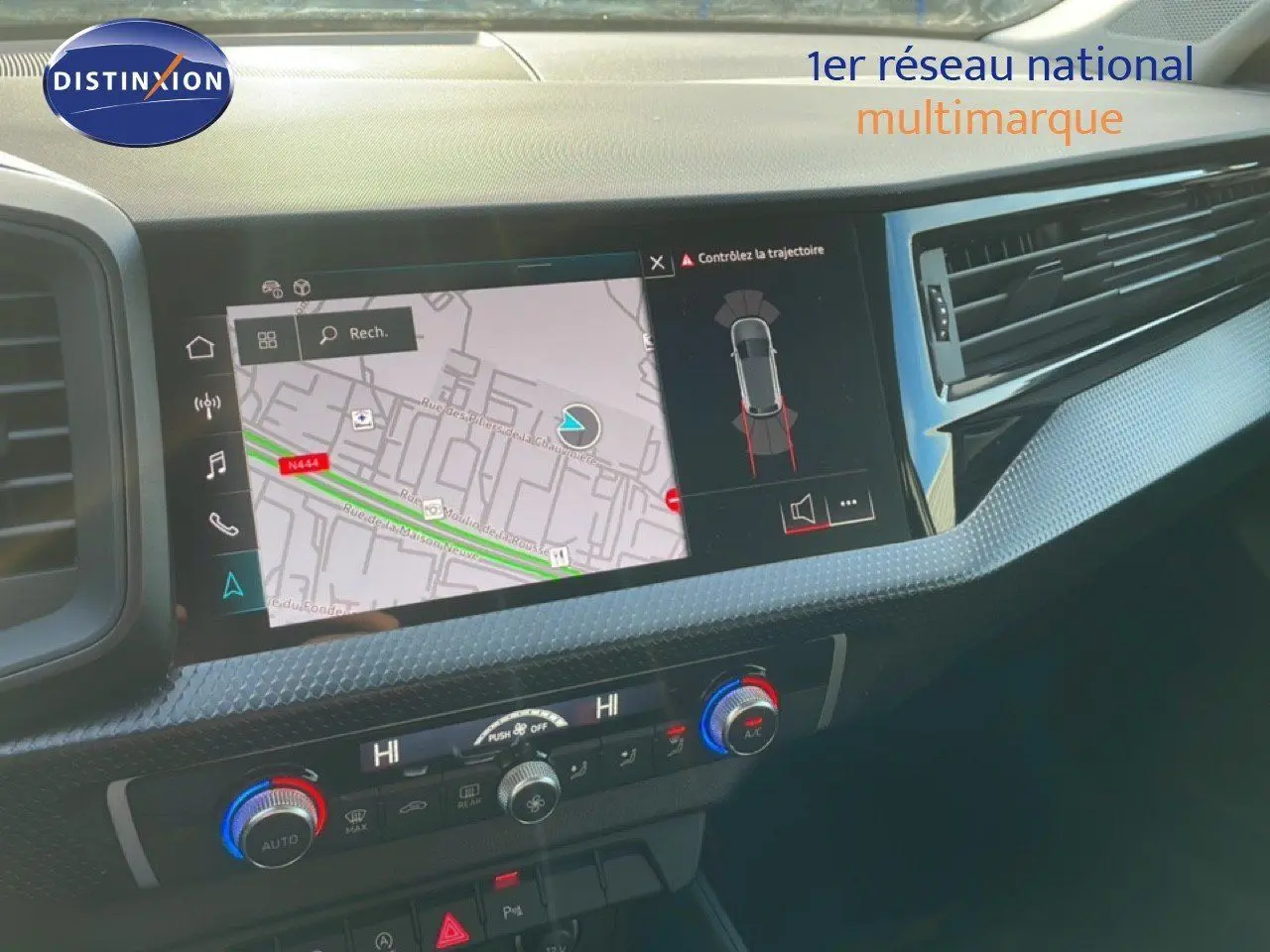 Vue rapprochée de l'écran tactile et de la console centrale de l'Audi A1 Sportback 2023 en blanc glacier métal, affichant la navigation.