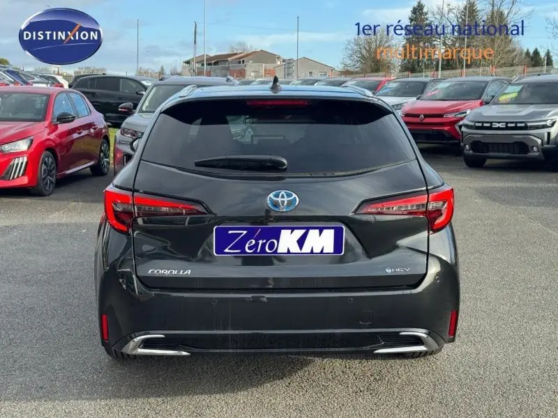 Vue arrière d'une Toyota Corolla noire 2025 hybride avec feux arrière LED et double sortie d'échappement chromée.