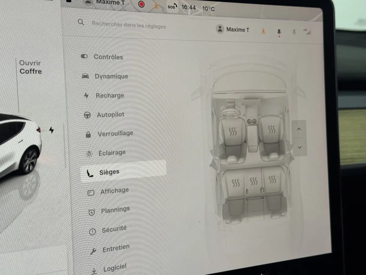 Écran tactile central montrant les réglages des sièges chauffants d’une Tesla Model Y blanche, vue intérieure.