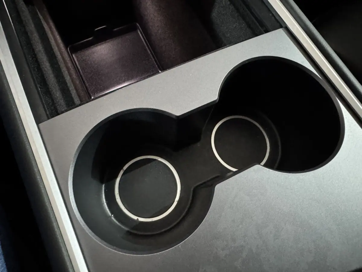 Gros plan sur les porte-gobelets noirs et argentés du Tesla Model Y Grand Autonomie intérieur.