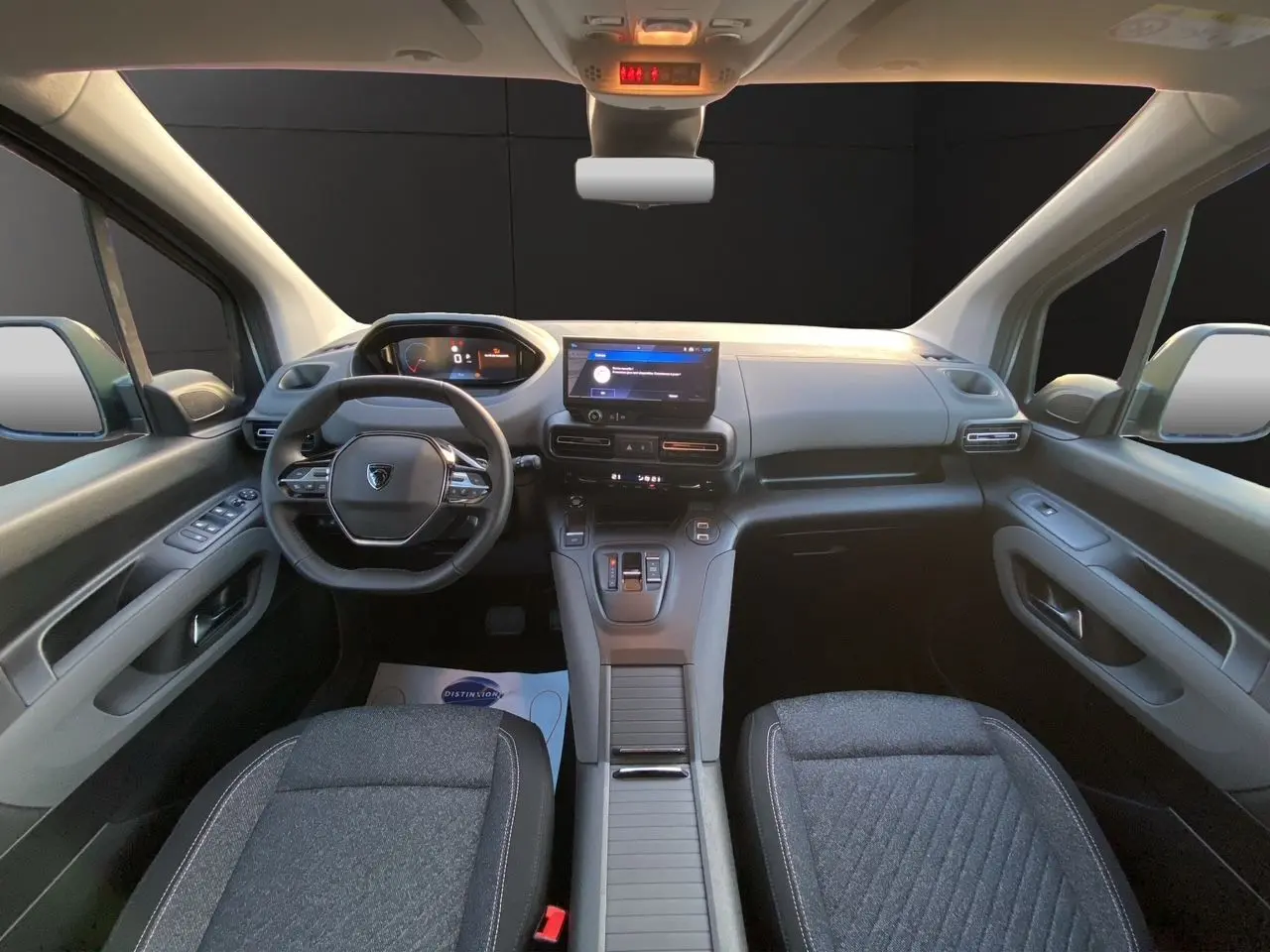 Vue intérieure avant du Peugeot Rifter 2026, tableau de bord moderne avec écran tactile et volant compact multifonction.