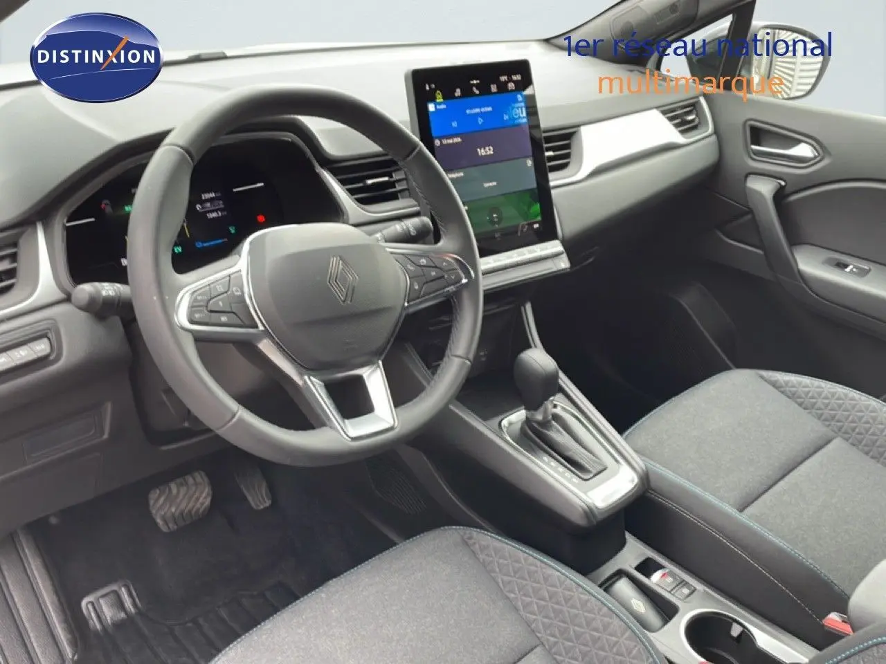 Vue intérieure côté conducteur du Renault Symbioz gris Rafale Métal, avec volant multifonction et écran tactile central vertical.