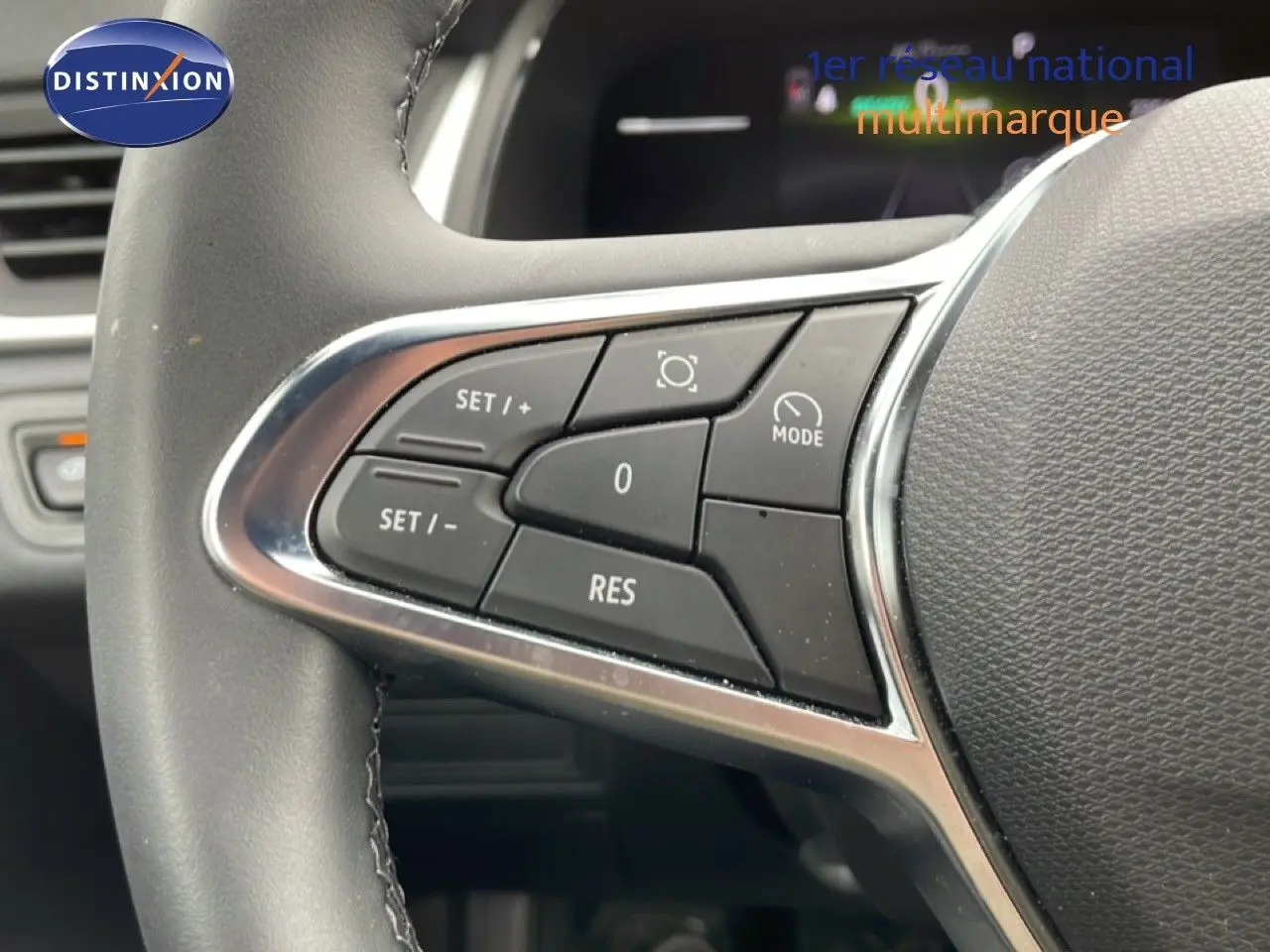 Gros plan sur les commandes de régulateur de vitesse au volant d’une Renault Symbioz gris Rafale Métal, intérieur noir.