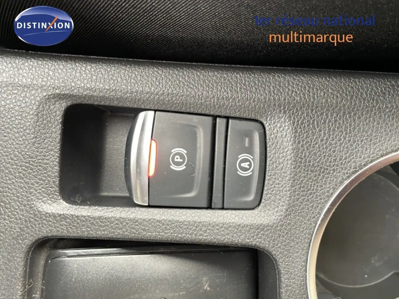 Gros plan sur les commandes de frein à main électronique et arrêt automatique du moteur, intérieur noir du Renault Symbioz.