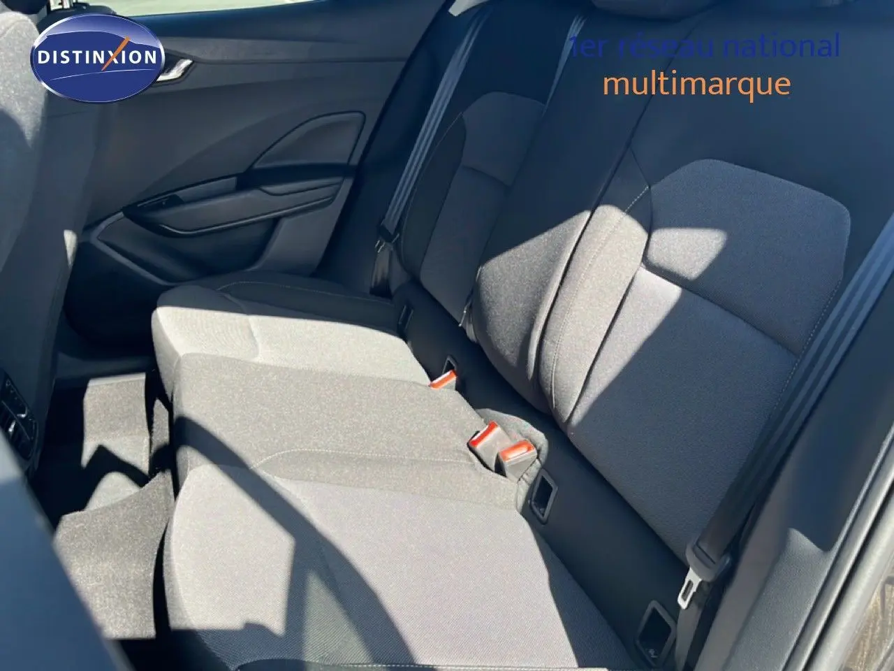 Vue intérieure des sièges arrière en tissu gris noir de la Skoda Fabia 2025, avec ceinture de sécurité et porte côté gauche visible.