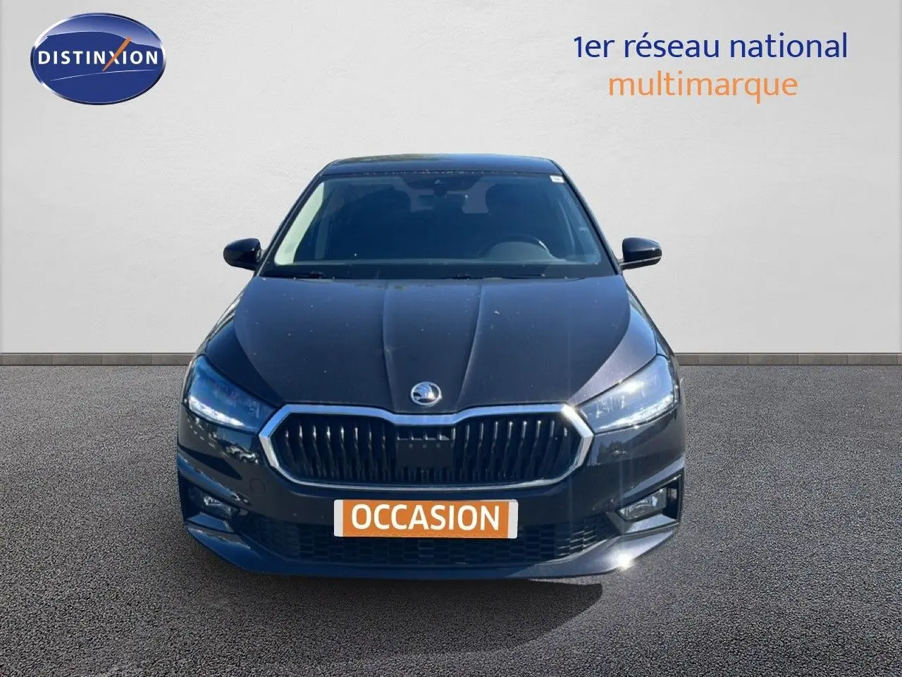 Vue de face d'une Skoda Fabia noire métal 2025 avec calandre chromée et phares LED allumés.