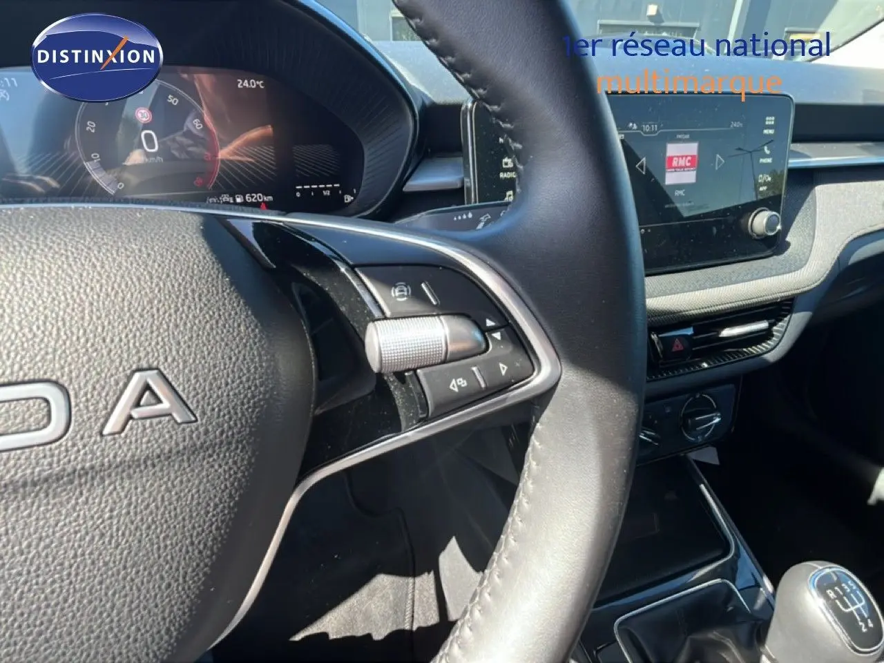 Vue intérieure centrée sur le volant et tableau de bord de la Skoda Fabia 2025, avec levier de vitesse manuel visible.