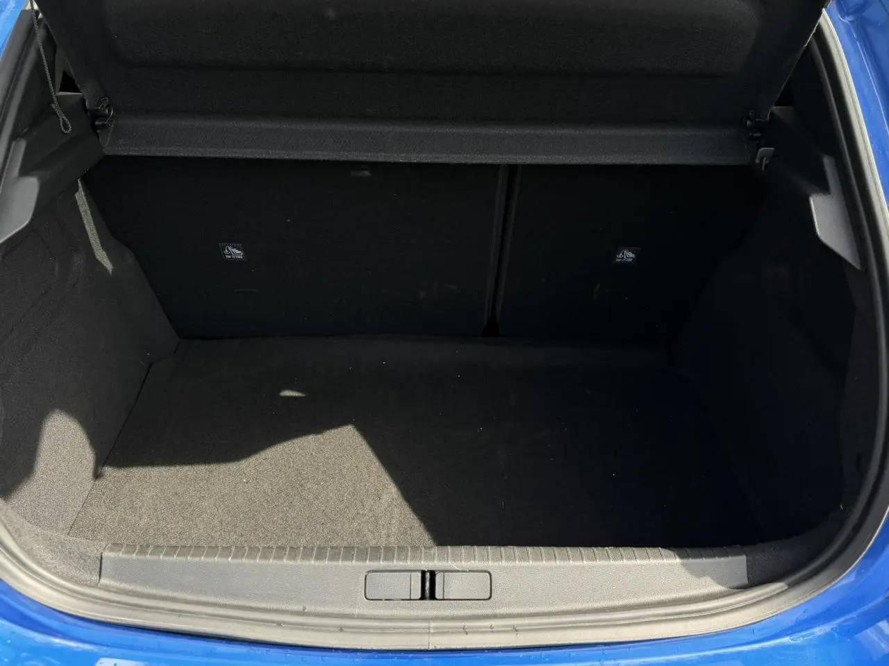 Coffre ouvert vu de l'arrière d'une Opel Corsa 2025 bleu Voltaic, montrant l'espace de chargement vide.