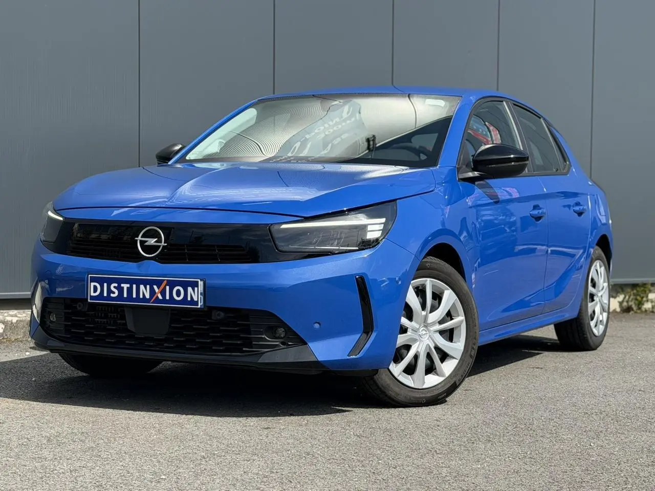 Opel Corsa bleu Voltaic vue 3/4 avant droit avec calandre noire et phares LED distinctifs.