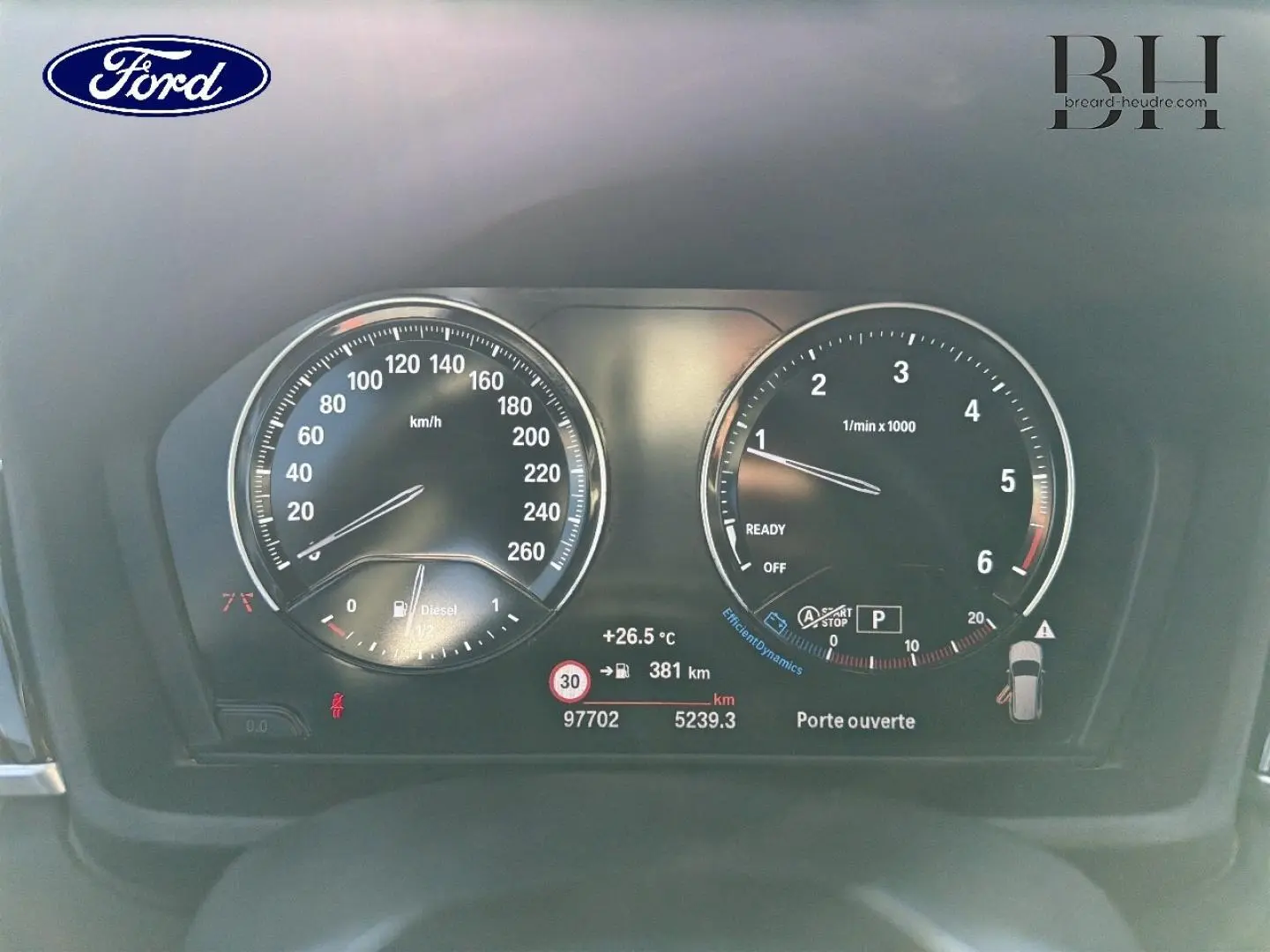 Tableau de bord BMW X1 sDrive18dA 2018 avec compte-tours, compteur vitesse, affichage digital et alertes visibles.