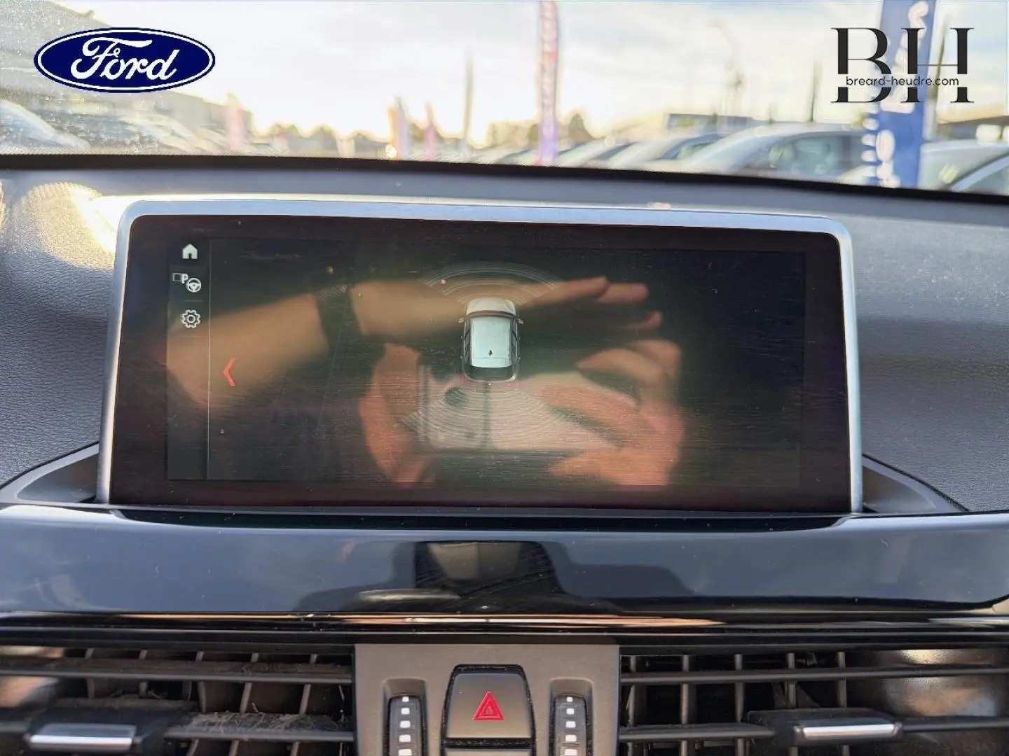 Écran central du tableau de bord d'une BMW X1 2018, vue frontale intérieure avec affichage de caméra de recul.