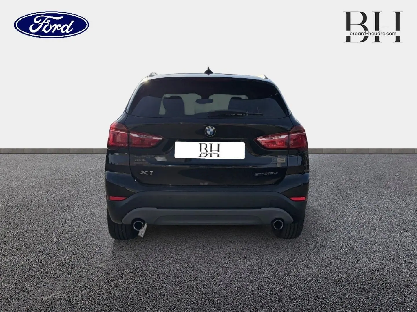 Vue arrière d'un BMW X1 sDrive18dA 2018 noir Saphirschwarz avec double sortie d'échappement et feux rouges.