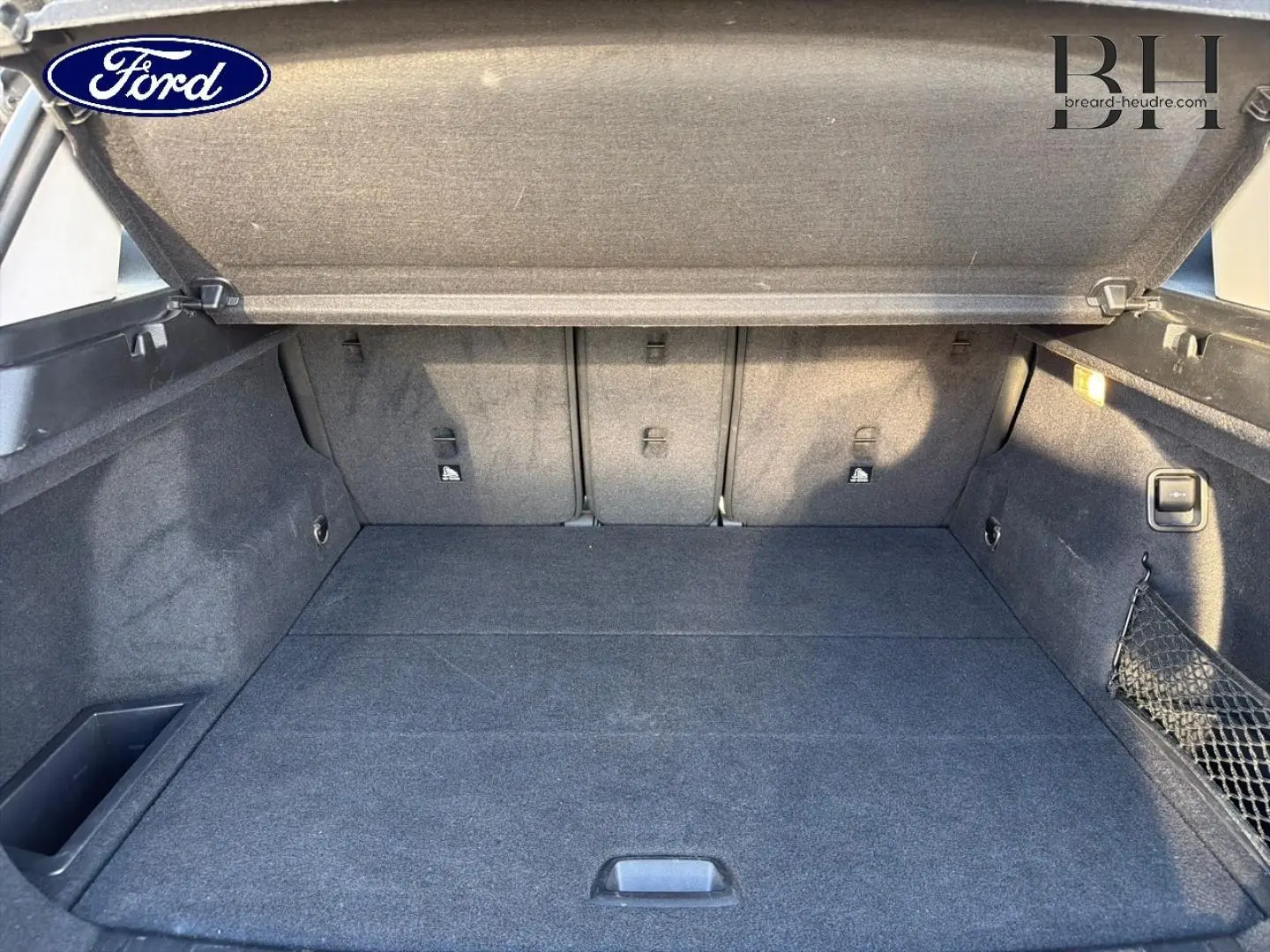 Coffre ouvert vu de l'intérieur d'une BMW X1 sDrive18dA 2018 en Saphirschwarz, avec habillage tissu gris.