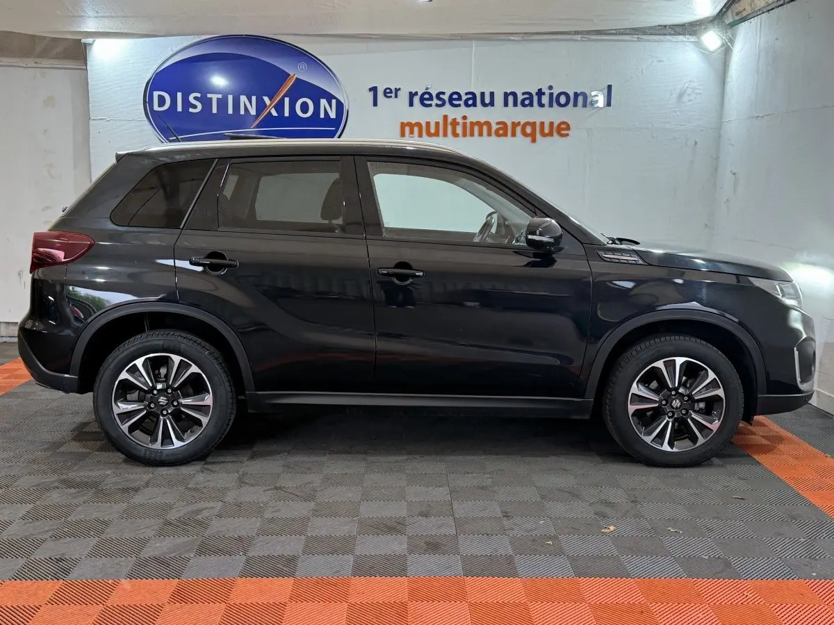 Vue de profil côté gauche d'un Suzuki Vitara noir 2022 avec jantes alliage et toit ouvrant électrique en verre.
