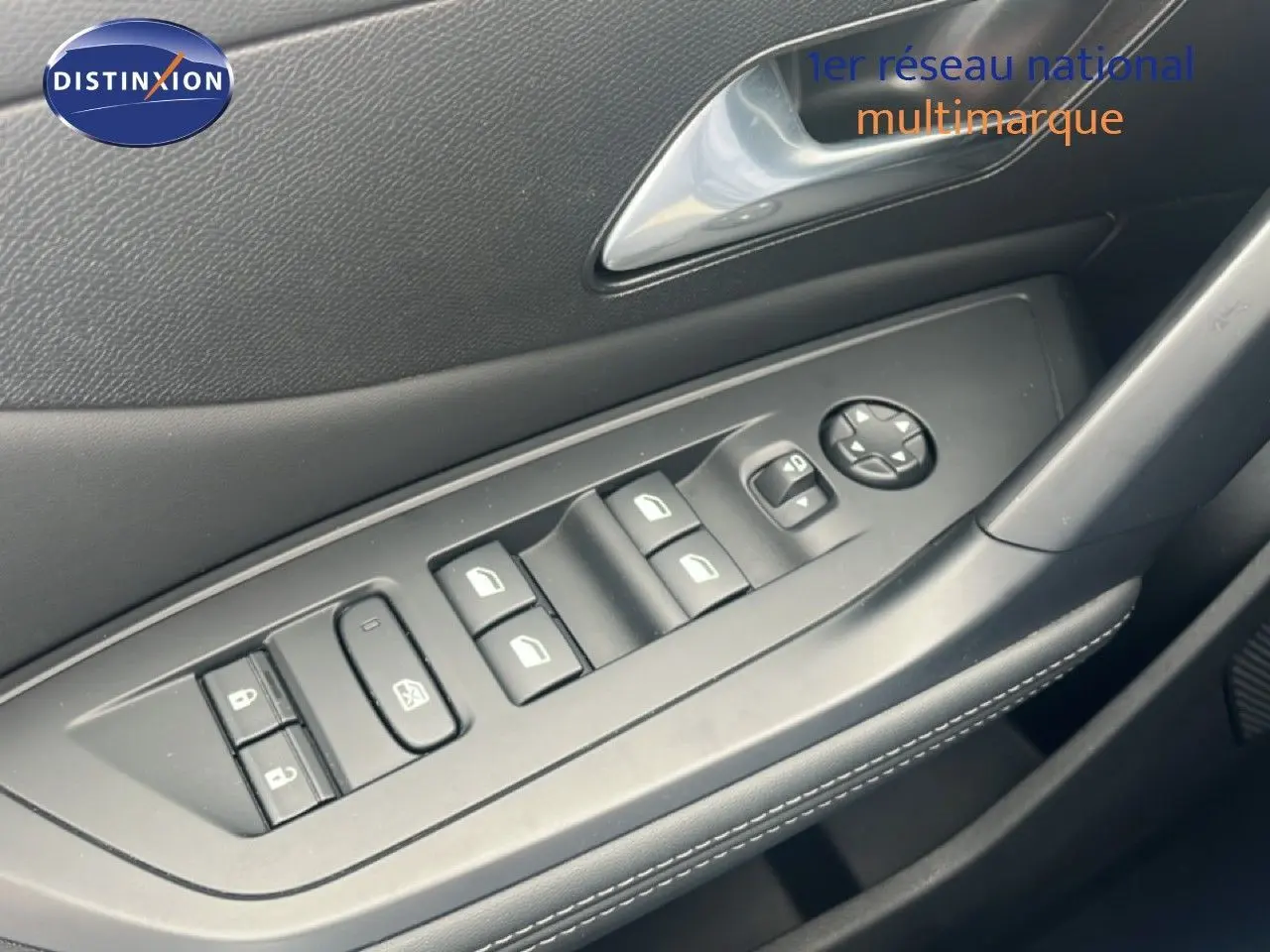 Gros plan sur la commande des vitres électriques côté conducteur de la Peugeot 308 2024, intérieur noir avec surpiqûres blanches.