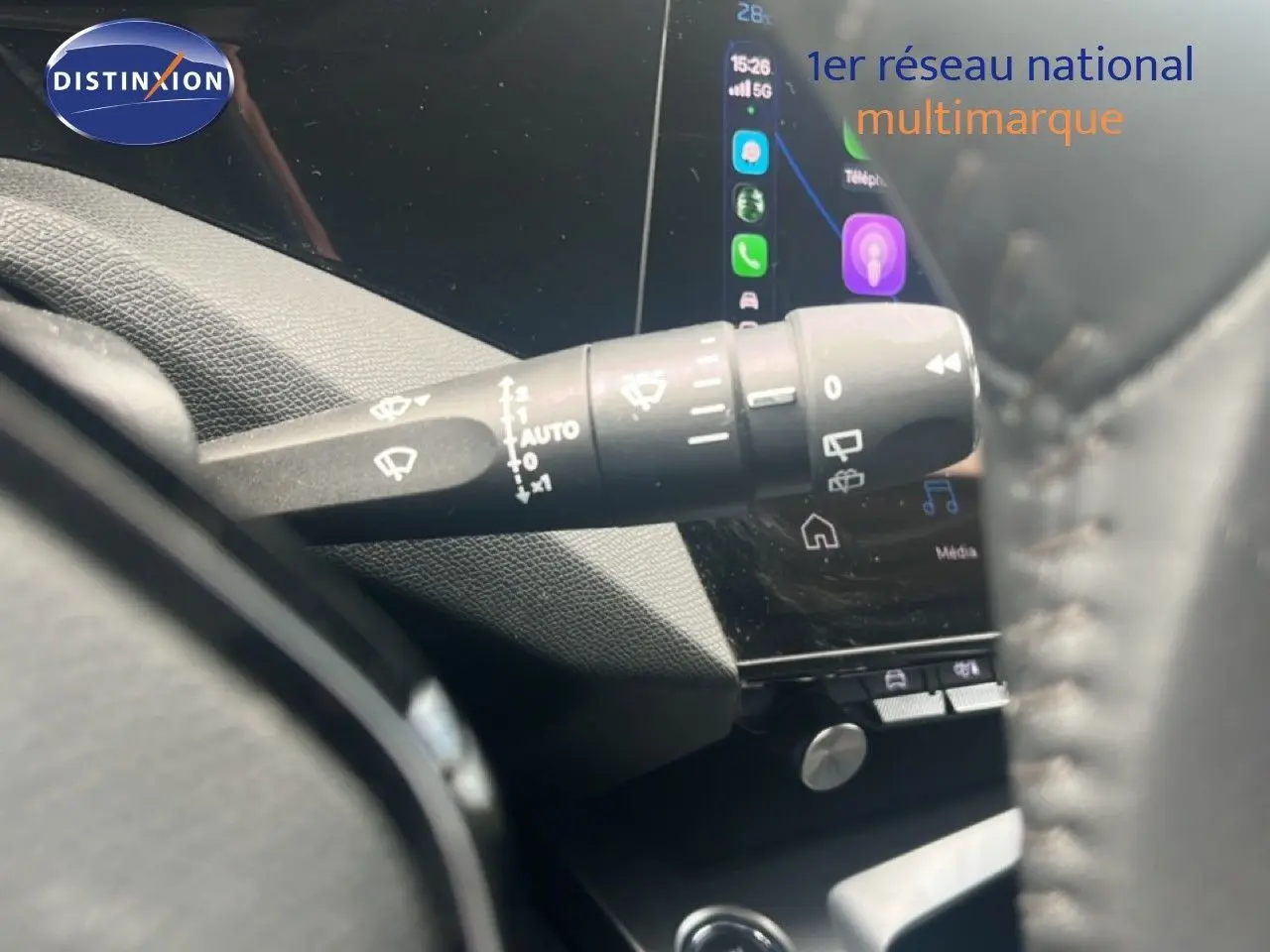 Gros plan sur la commande d’essuie-glace à gauche du volant dans l’habitacle d’une Peugeot 308 vert olivine 2024.