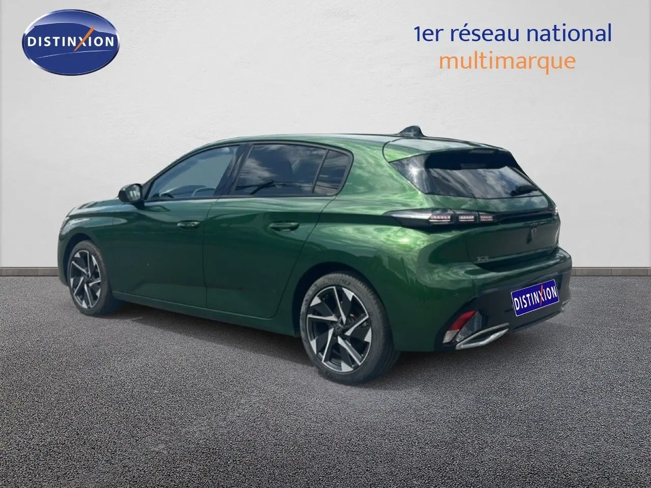 Vue 3/4 arrière droite d'une Peugeot 308 2024 vert olivine métallisé avec jantes alliage et vitres teintées.