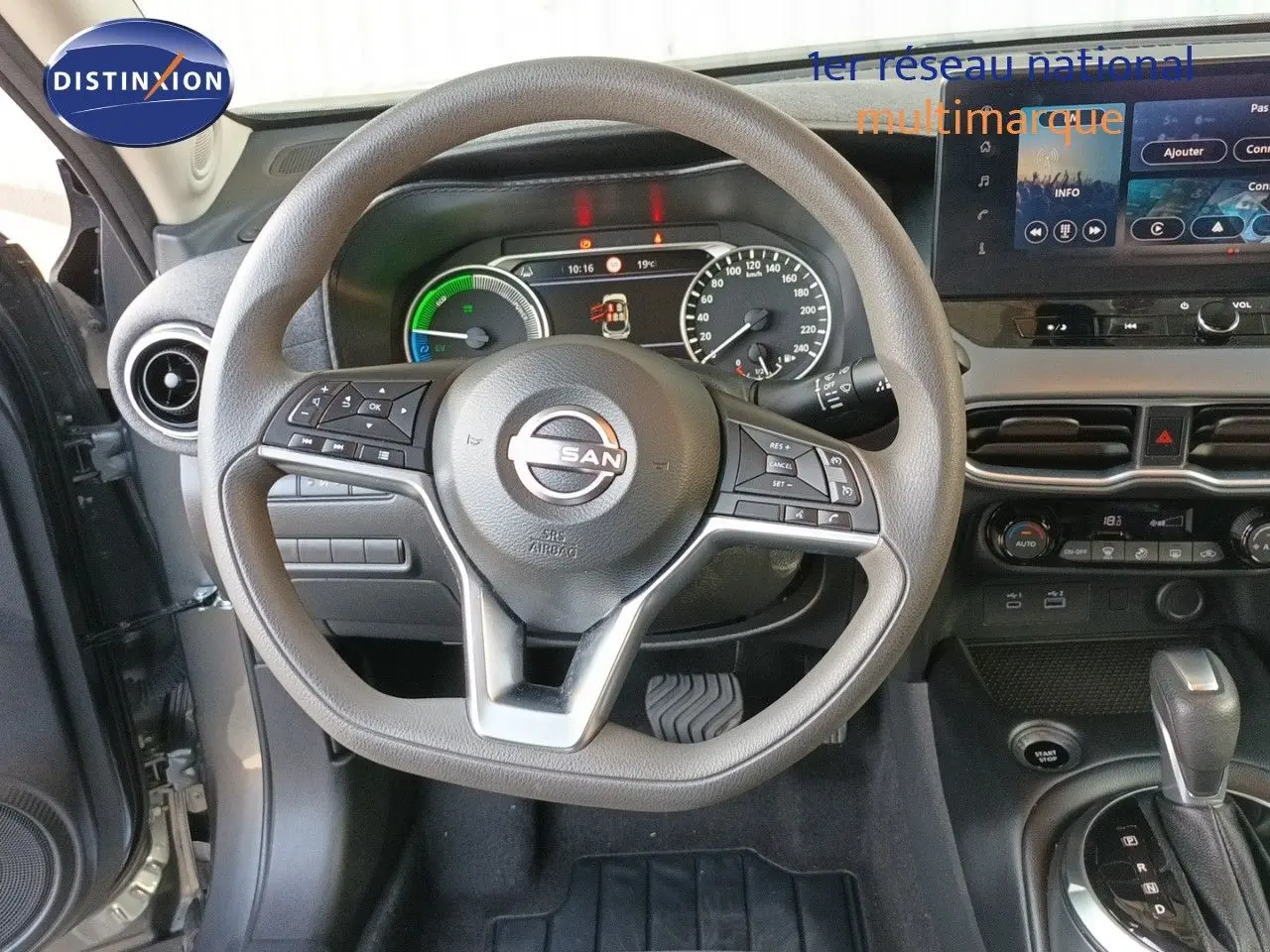Vue intérieure centrée sur le volant Nissan Juke 2025, tableau de bord et console avec écran tactile et commandes intégrées.