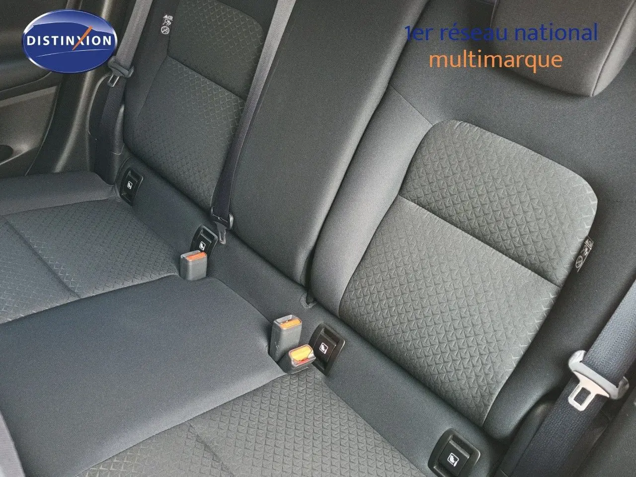 Vue rapprochée des sièges arrière en tissu gris foncé du Nissan Juke Hybrid 2025, avec ceintures et ancrages ISOFIX visibles.