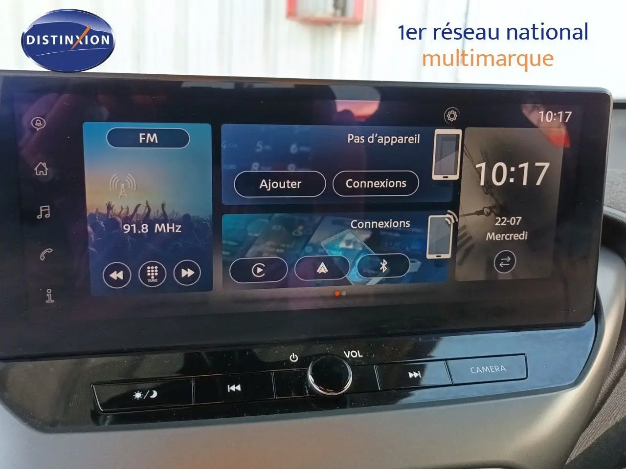 Écran tactile central du Nissan Juke Hybrid 2025 affichant la radio FM et les options de connexion, vue intérieure frontale.