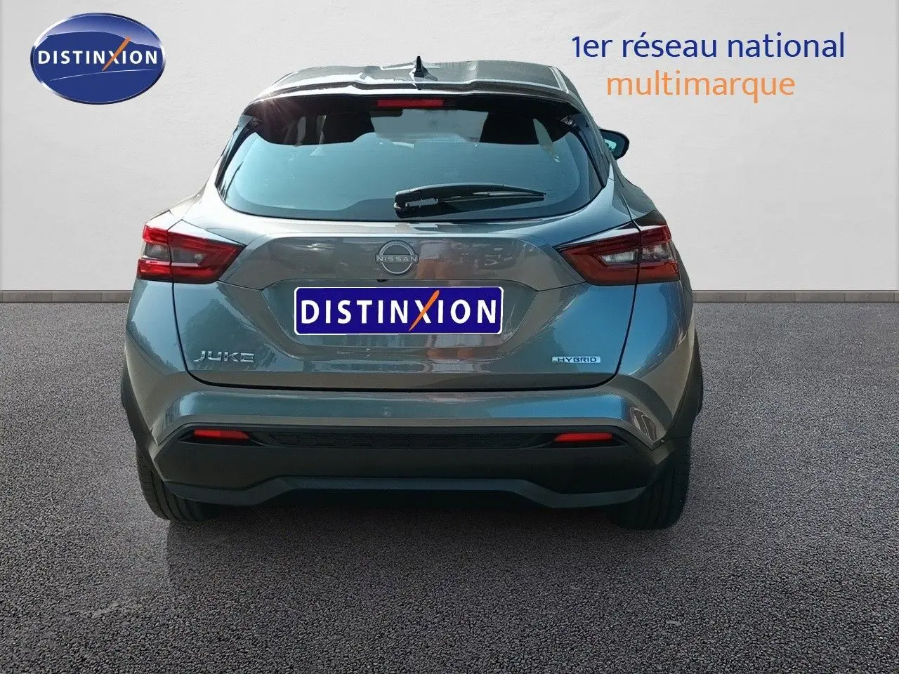 Vue arrière d'un Nissan Juke hybride gris squale métal 2025 avec feux arrière LED et logo distinctif.