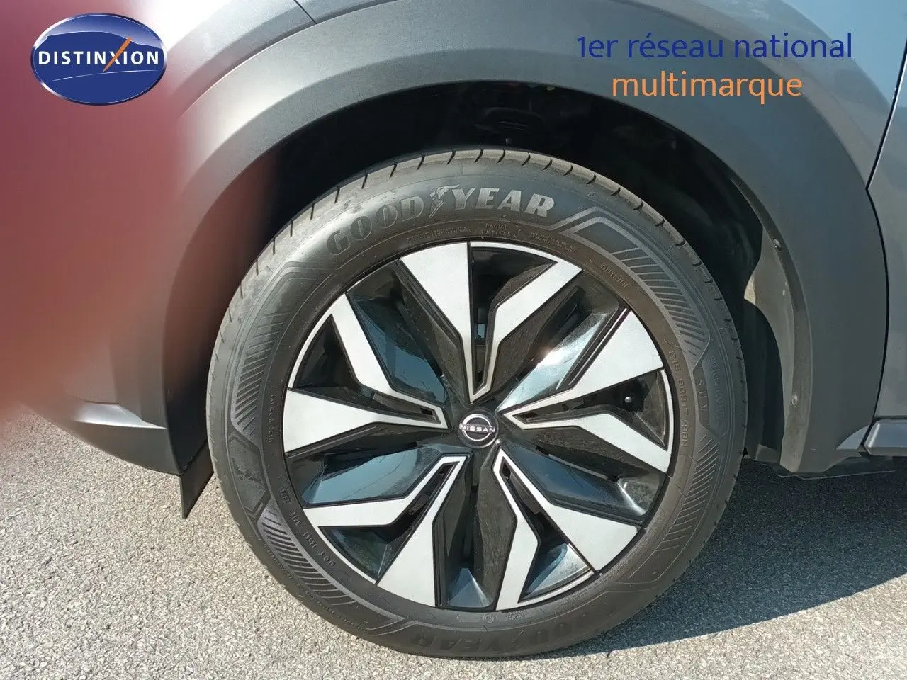 Gros plan sur la roue avant droite du Nissan Juke 2025 gris squale métal avec jante alliage noire et argentée.