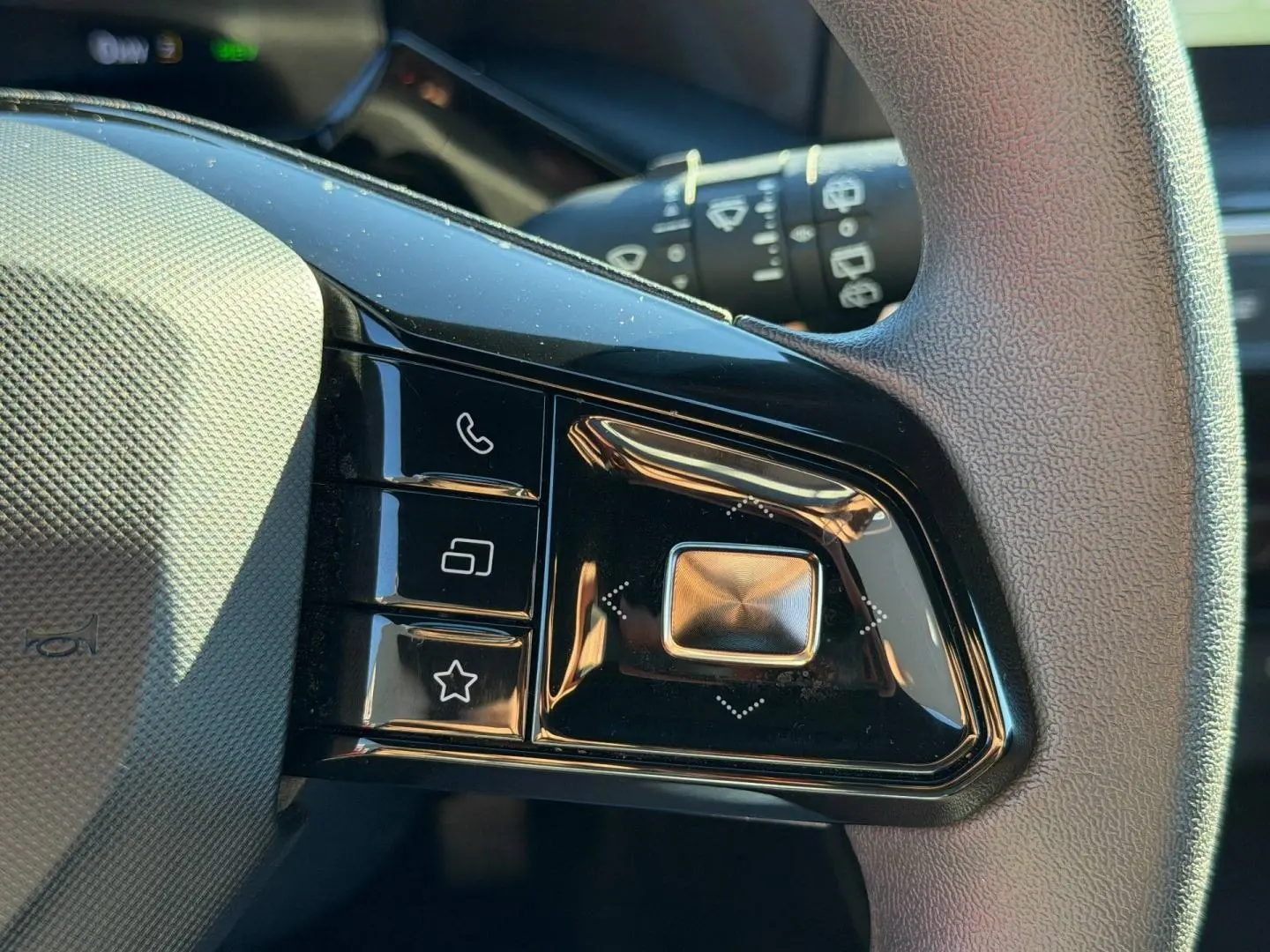Gros plan sur les commandes noires du volant côté gauche du MG3 1.5 Hybrid+ 2024 en Como Blue métallisé.