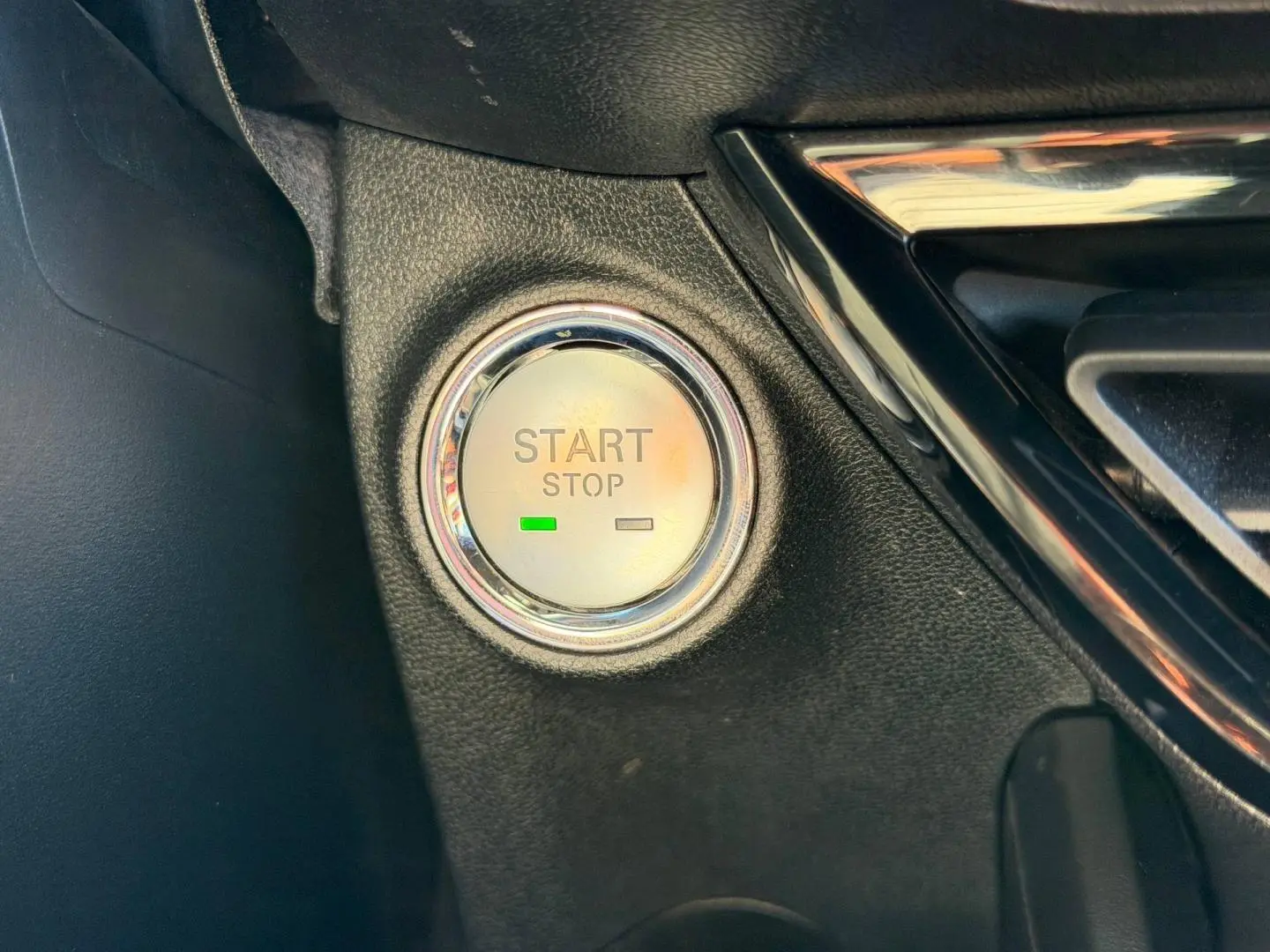 Gros plan sur le bouton Start/Stop entouré de chrome dans l’habitacle noir du MG3 1.5 Hybrid+ 2024.