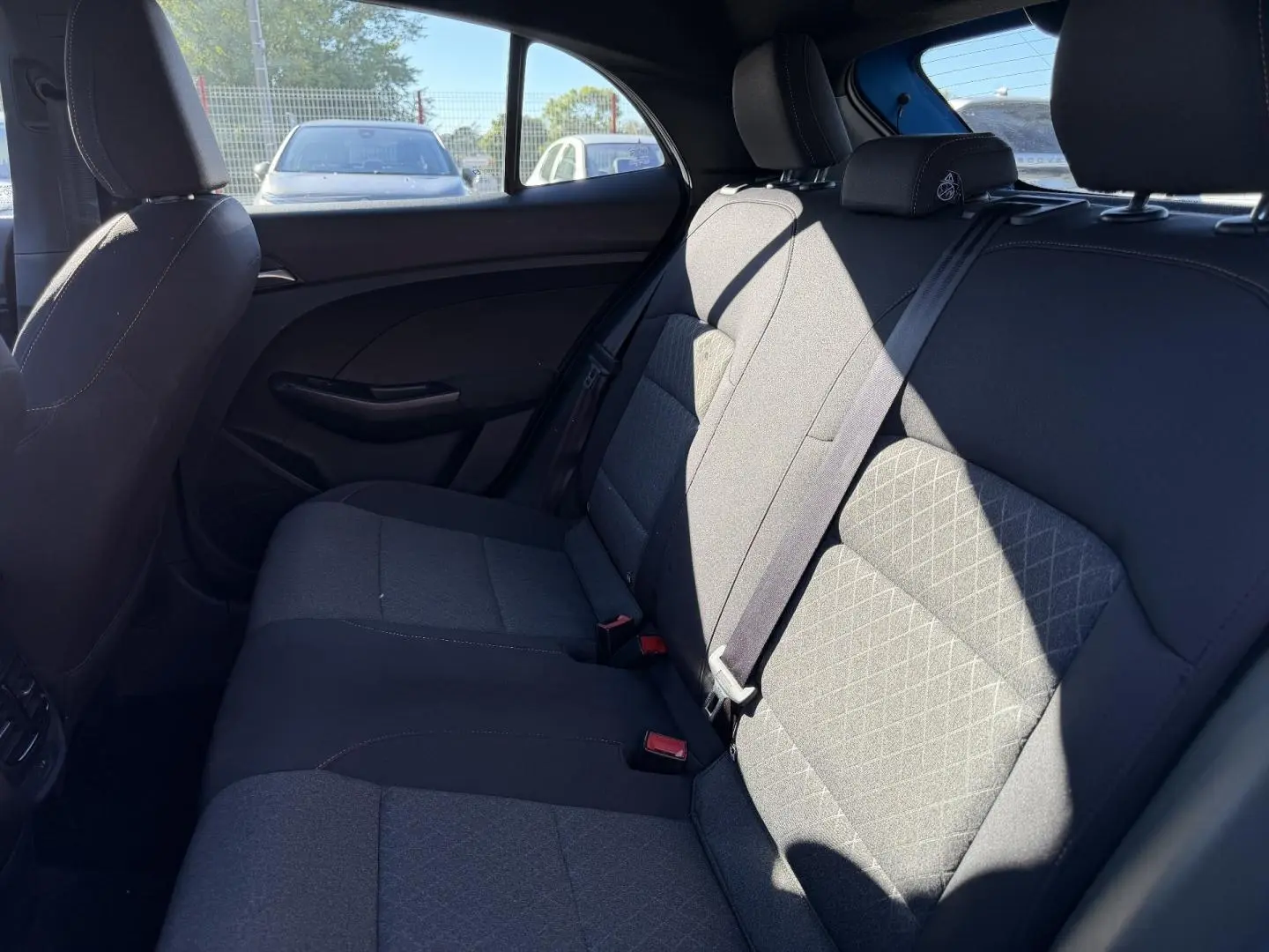 Vue latérale intérieure des sièges arrière en tissu noir du MG3 1.5 Hybrid+ 195ch Comfort, avec ceinture de sécurité.