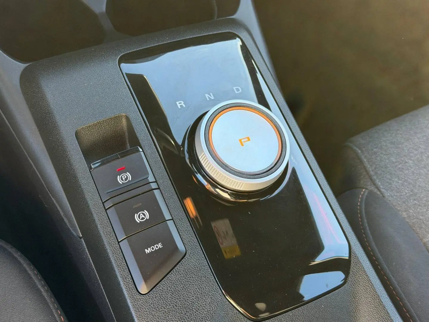 Gros plan sur la molette de boîte automatique et commandes noires du console centrale du MG3 1.5 Hybrid+ 2024.