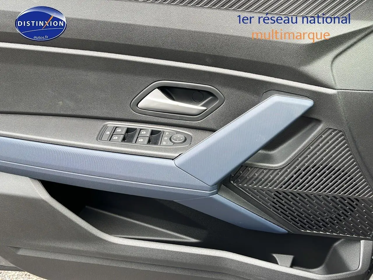 Gros plan sur la porte avant gauche du Dacia Duster gris schiste, avec commandes électriques et haut-parleur intégré.