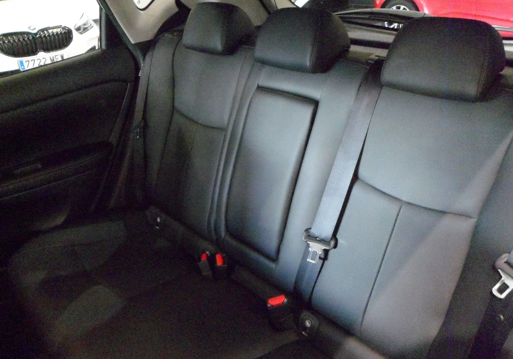 Banquette arrière en cuir noir de la Nissan Pulsar 2019, vue intérieure côté droit avec ceintures de sécurité visibles.