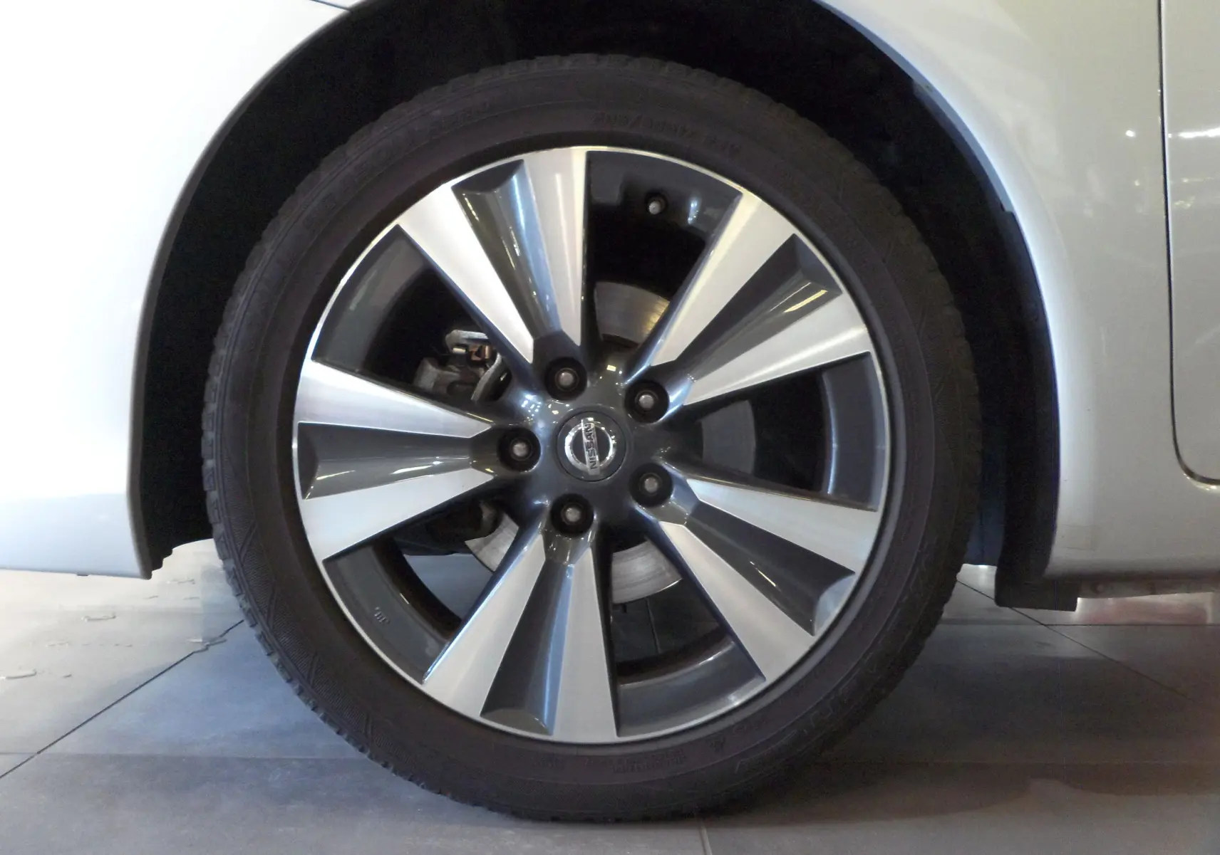 Gros plan sur la jante avant droite gris argenté de la Nissan Pulsar Gris Glacier 2019 avec logo central visible.