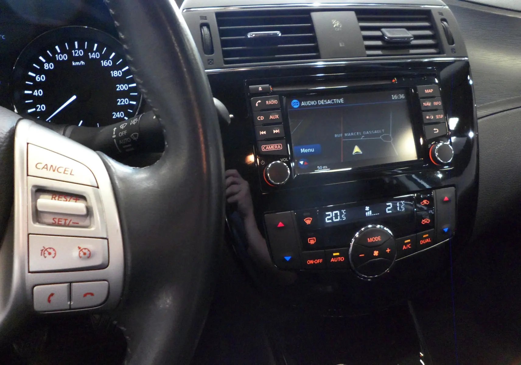 Vue intérieure du tableau de bord de la Nissan Pulsar 2019, avec écran tactile et commandes de climatisation digitales.